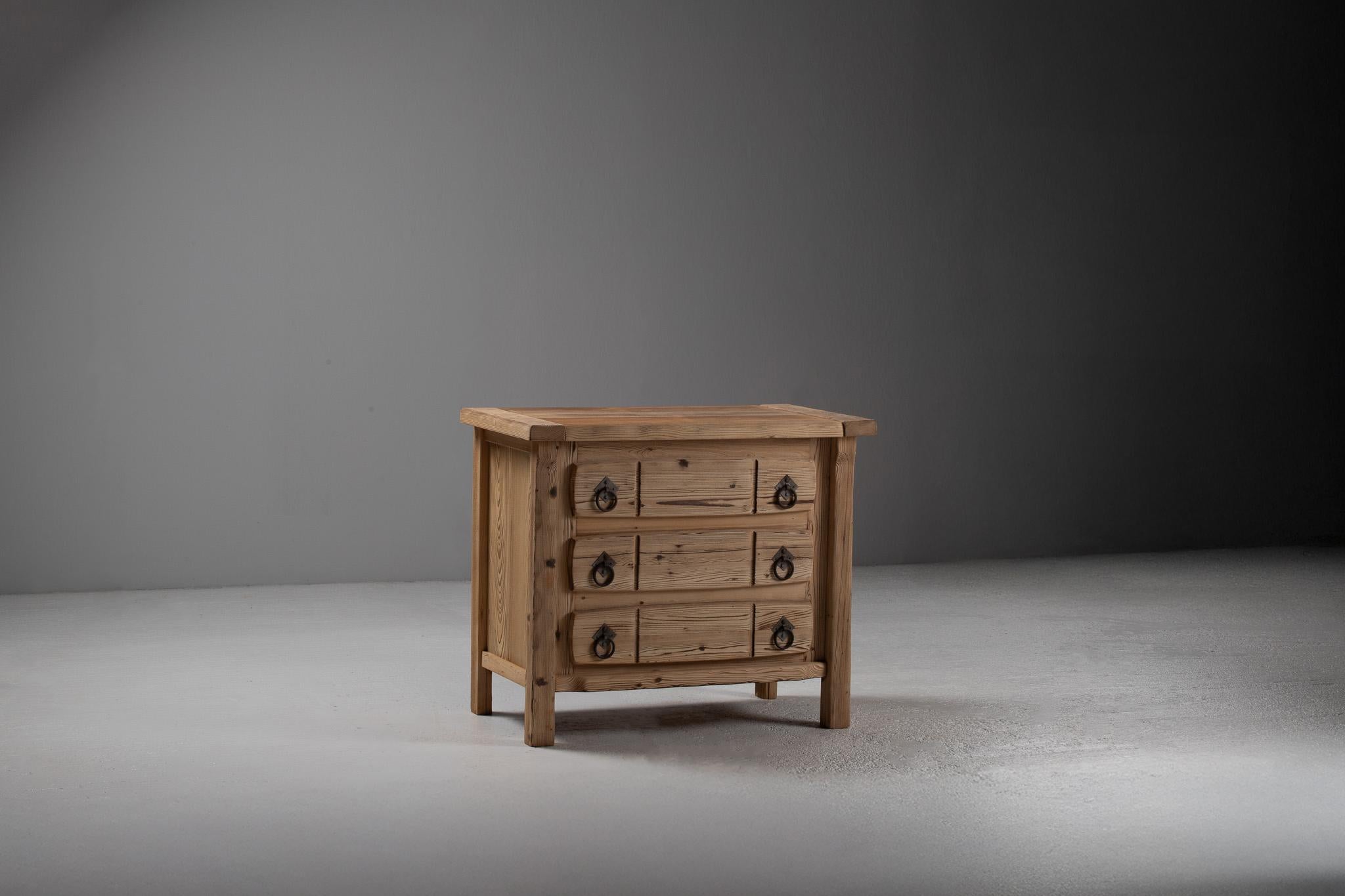 Tactile and grounded, this French chest of drawers from the 1940s embodies a rustic modernism steeped in simplicity. Carved from solid pine, the piece reveals the swirling grain and warm tonal shifts of the wood with sculptural clarity—its form