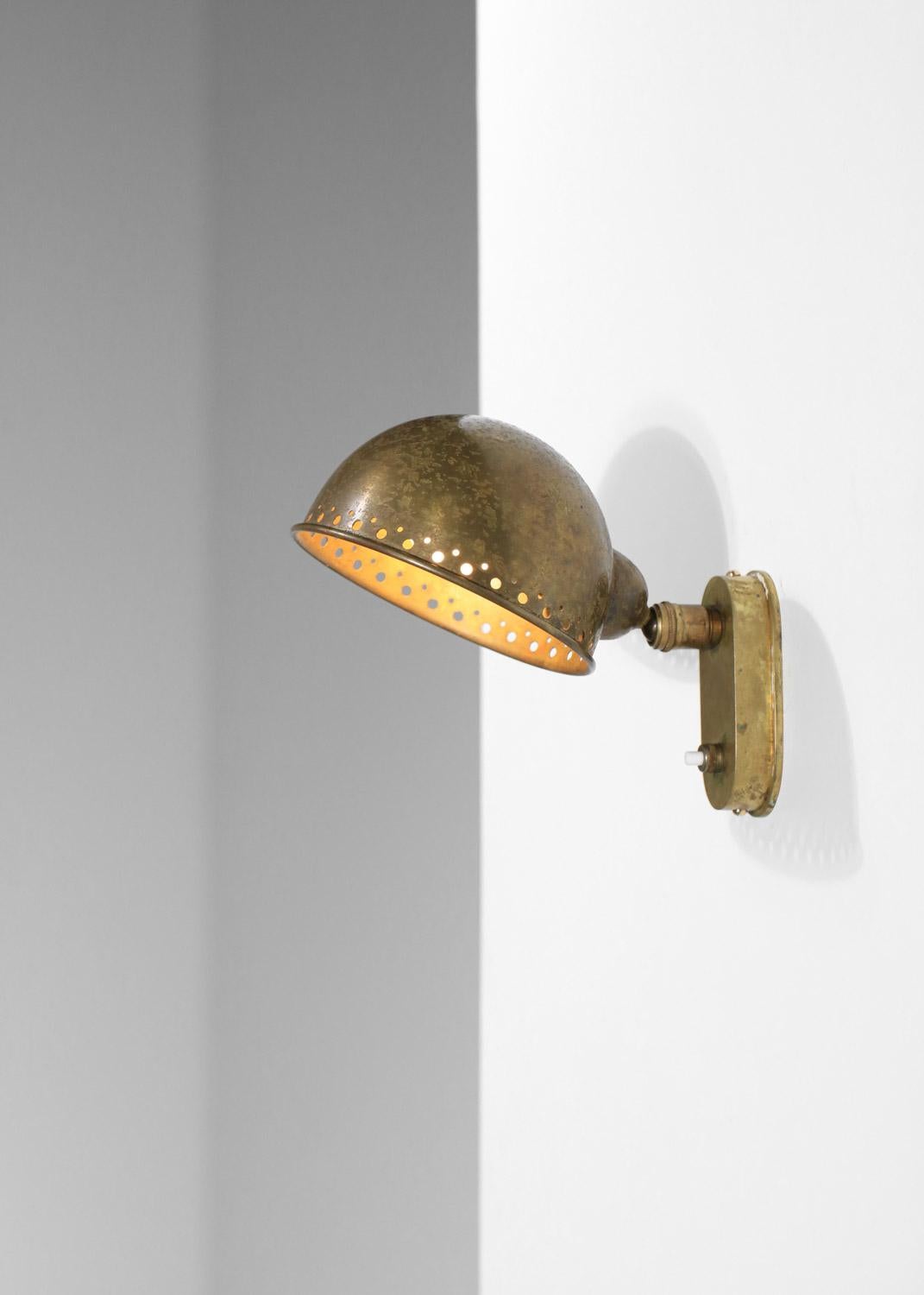 Lampada da parete francese degli anni '40/'50 attribuita ai designer Genet & Michon. Struttura in solido ottone ossidato, il paralume può essere ruotato grazie alla girella centrale. Condizioni vintage molto buone, con una bella patina di età