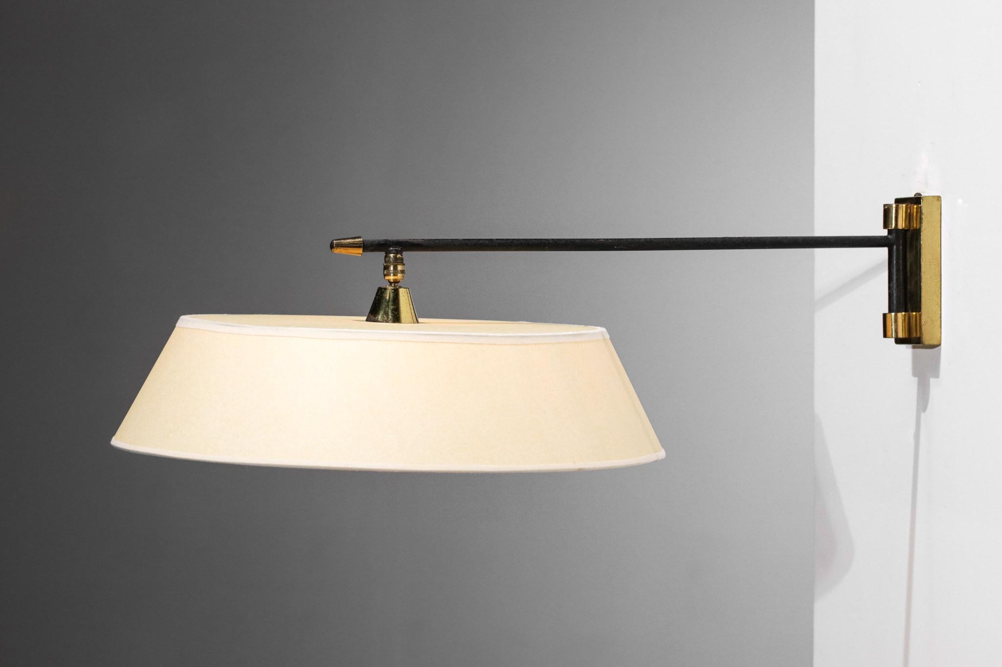1950's wall lamp edited by Maison Arlus. Arm in black lacquered metal, wall attachment and ball joint of the lampshade in solid brass. Possibility to orientate the lampshade according to the desire thanks to the ball joint (see pictures). Very nice