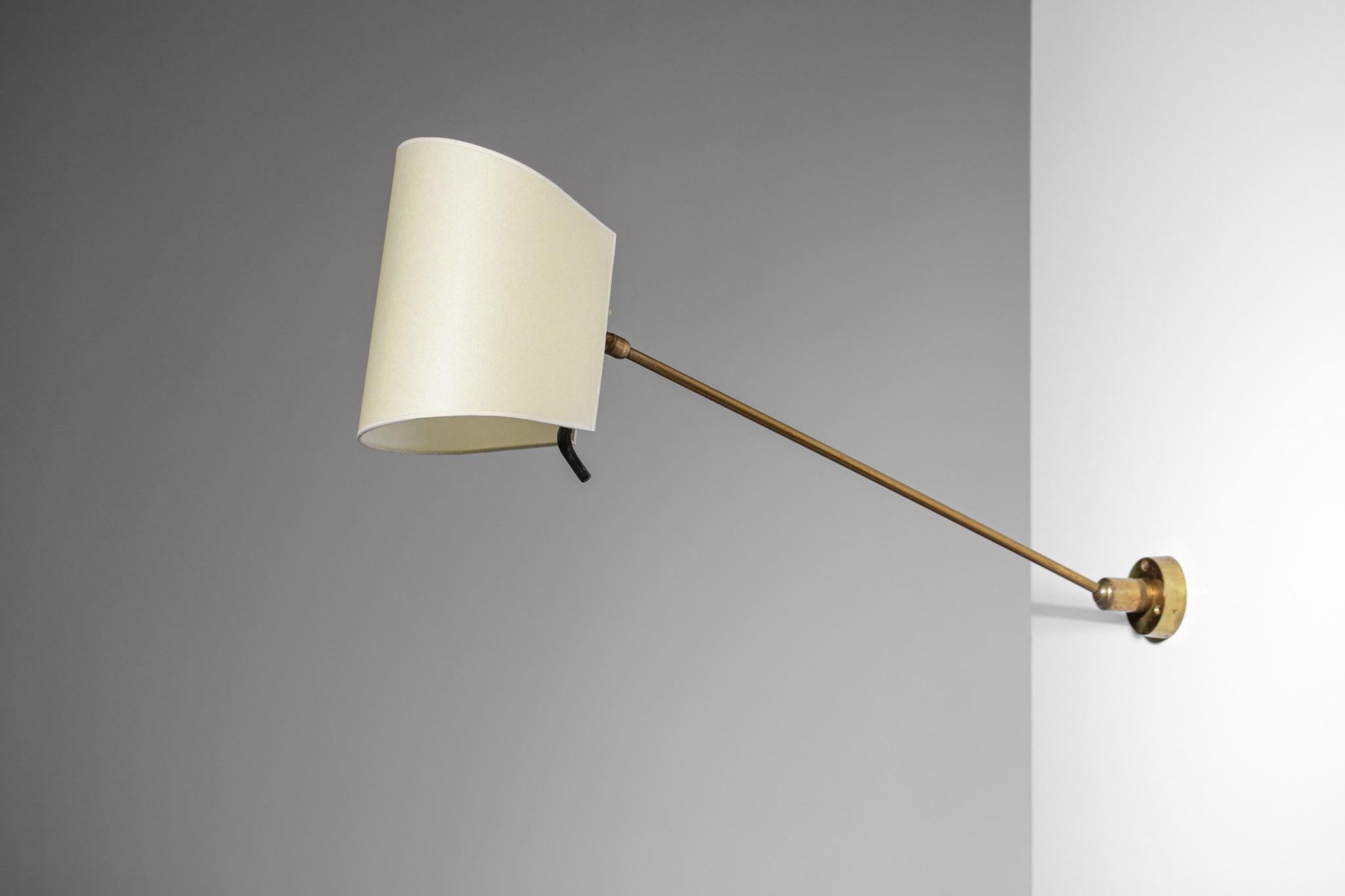 French wall lamp from the 50's, arm structure in black lacquered metal, base and ball joint in solid brass. Possibility to orientate the shade and the arm in different positions, double bulb lighting. Very sober but elegant design, lampshade