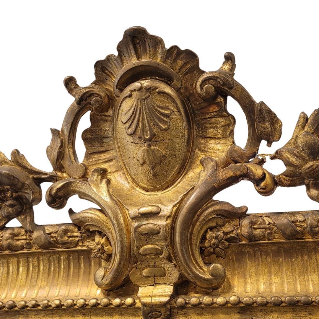 Unique and gorgeous  French mirror style and era Napoleon III, in carved and gilded wood with fine gold burnished with agate stone. Rectangular profile with the two upper corners rounded, and in its center rises an exquisite ornate copete or finish.