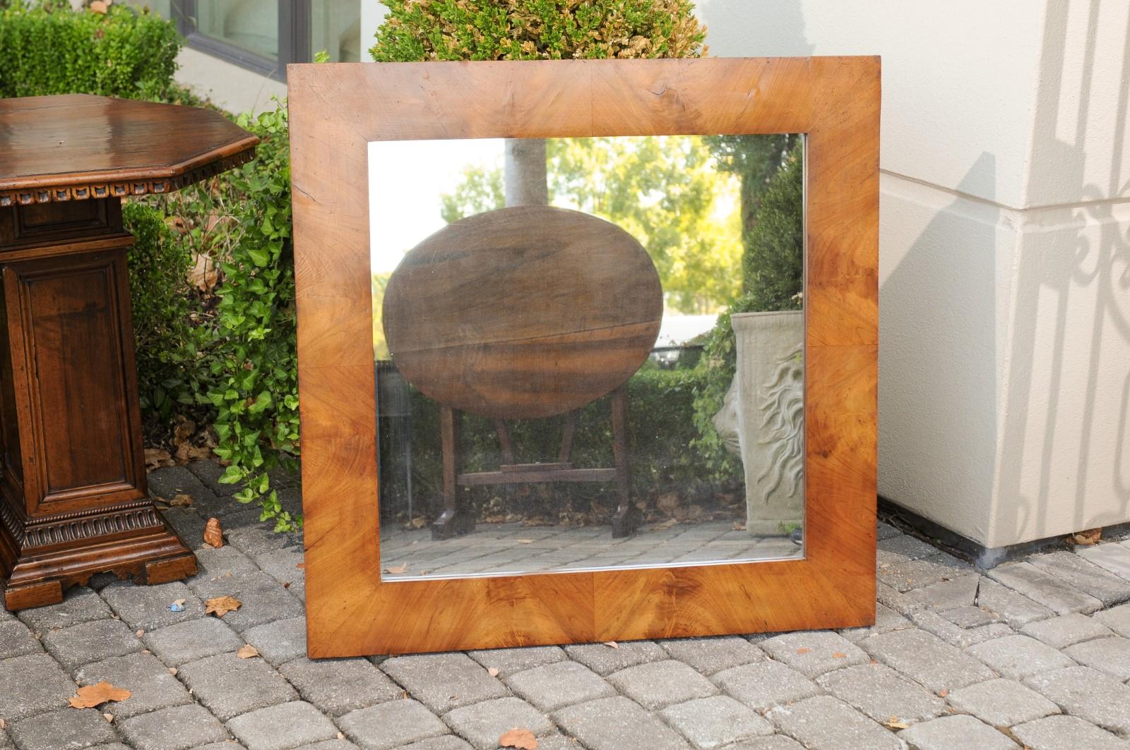 A French burl walnut mirror from the early 20th century. Born in France during the 