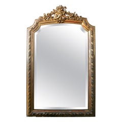 French Wall Mirror in Gilded Wood with the Coping Top Decorated with Instruments