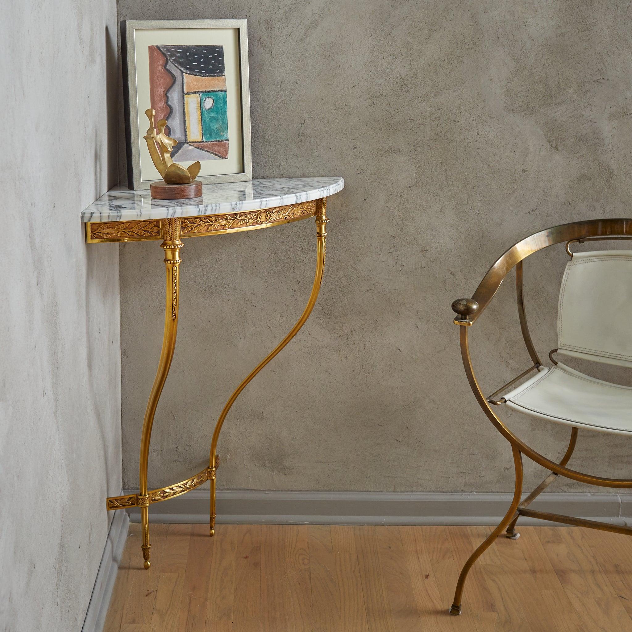 Venduto e prezzato singolarmente.

Questa consolle angolare francese degli anni '50 fonde perfettamente dettagli ornamentali e proporzioni eleganti. La struttura in ottone dorato, arricchita da delicate incisioni foliate e geometriche, presenta due