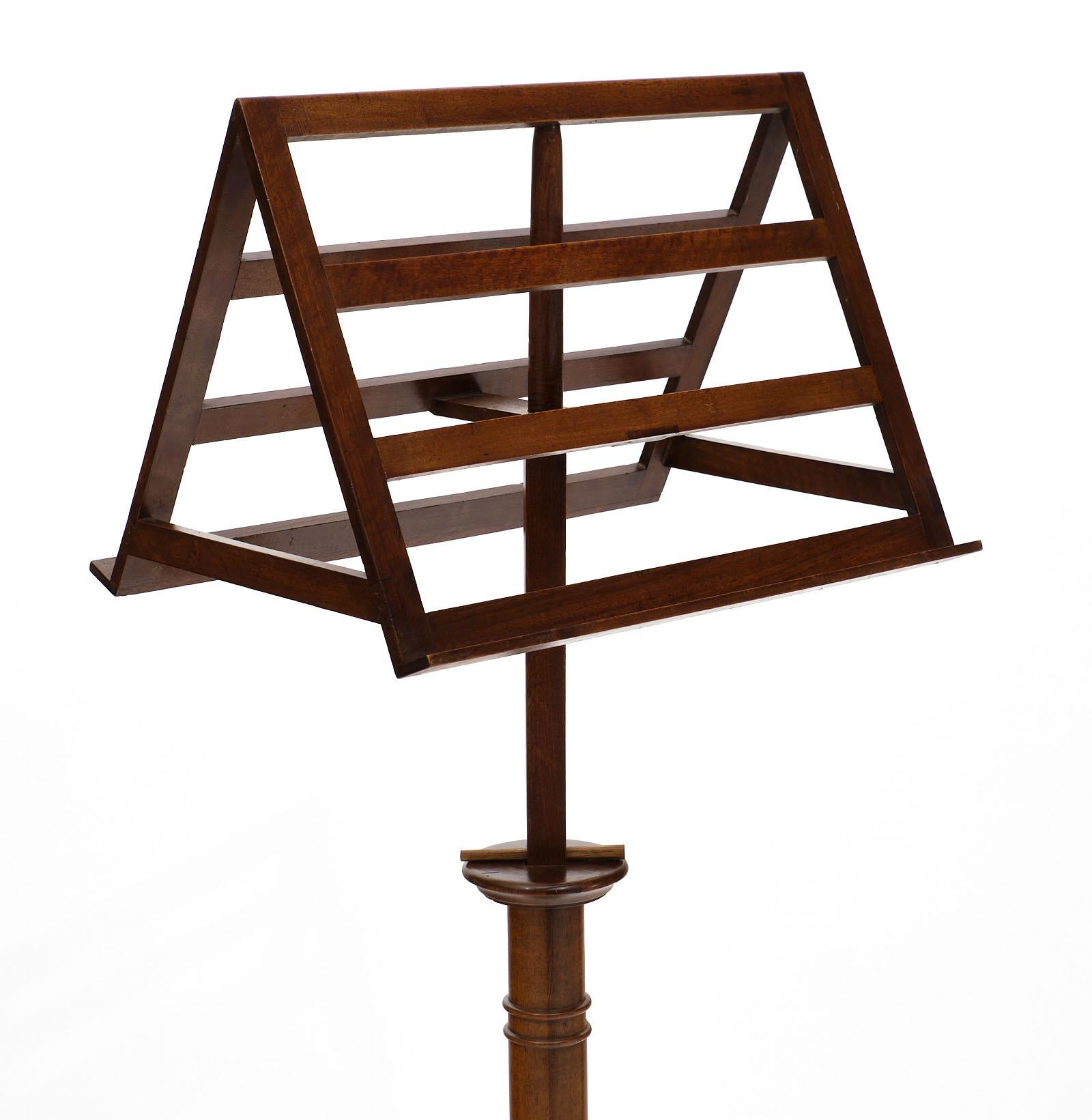 19th century French walnut lectern featuring a rotating stand on an adjustable stem. The solid walnut is hand carved into a single support resting on four hand carved feet. This is from a private chapel in the Rhone Valley.