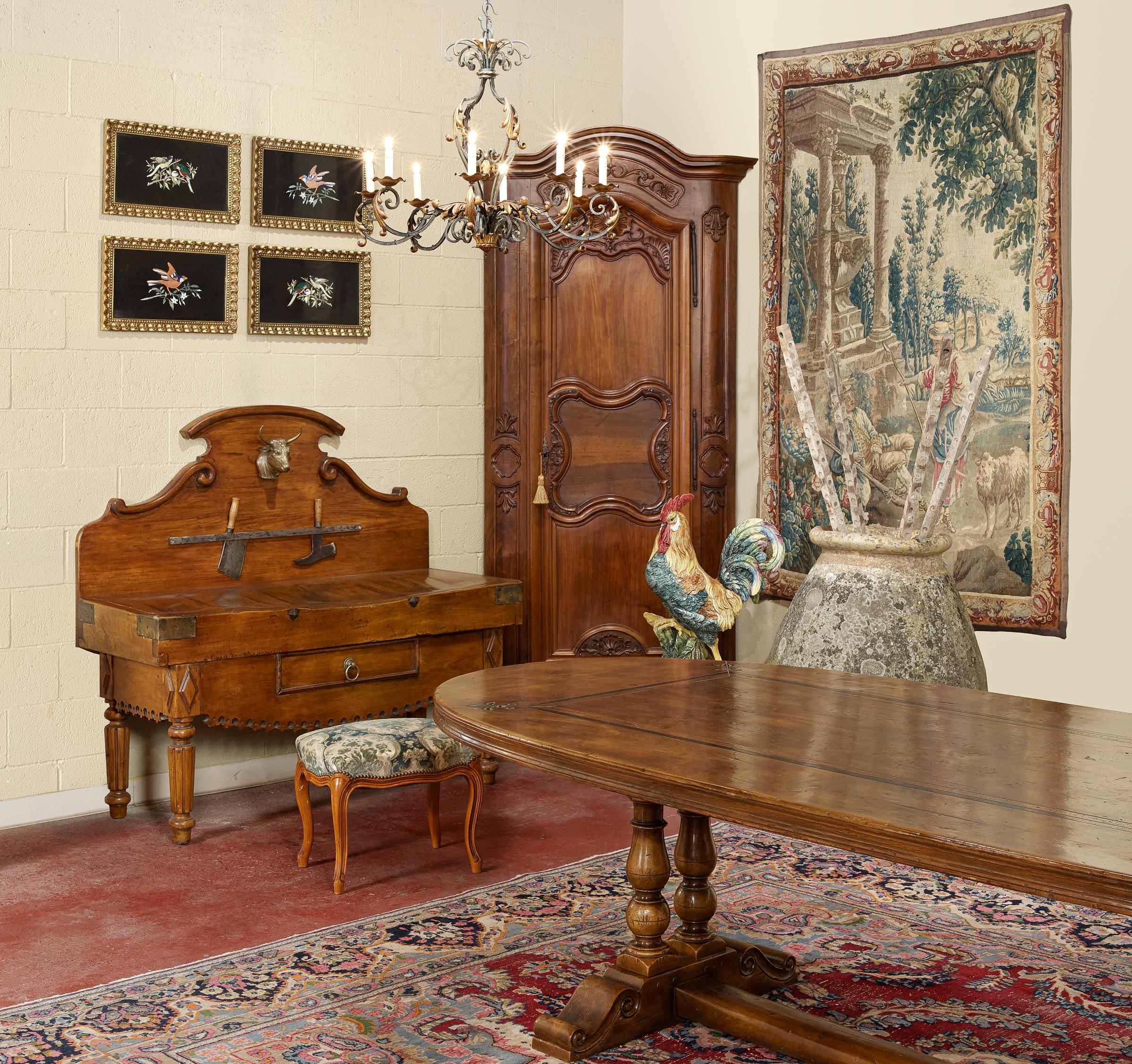 This elegant and large 10 foot dining table was crafted in the Pyrenees of France using antique timbers, and following an 18th century design. The oval table sits on a trestle base, supported by a pair of hand carved and turned double-legs connected