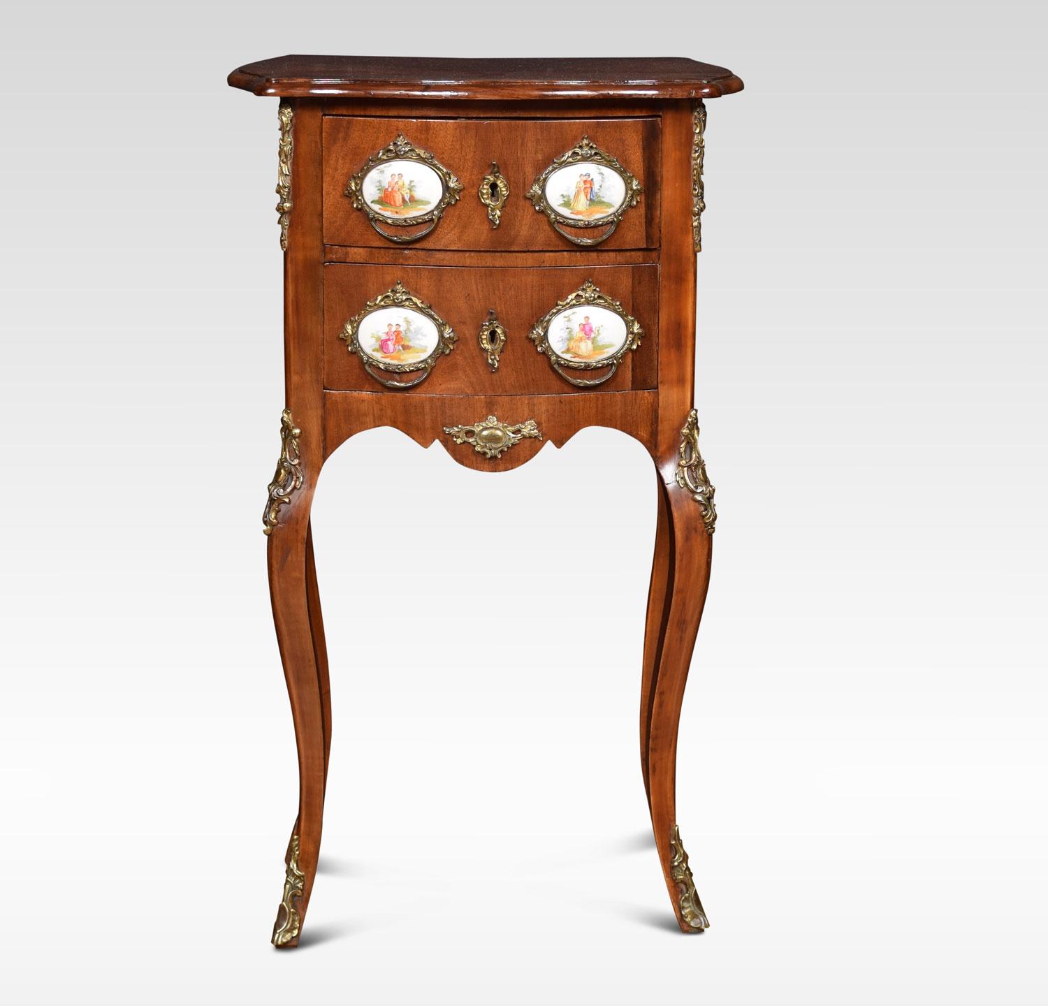Walnut and gilt metal chest of drawers, the top above two drawers with gilt foliate cast handles and oval porcelain plaques, above a shaped apron, raised on slender cabriole legs with foliate brass mounts and sabots.
Dimensions:
Height 27.5