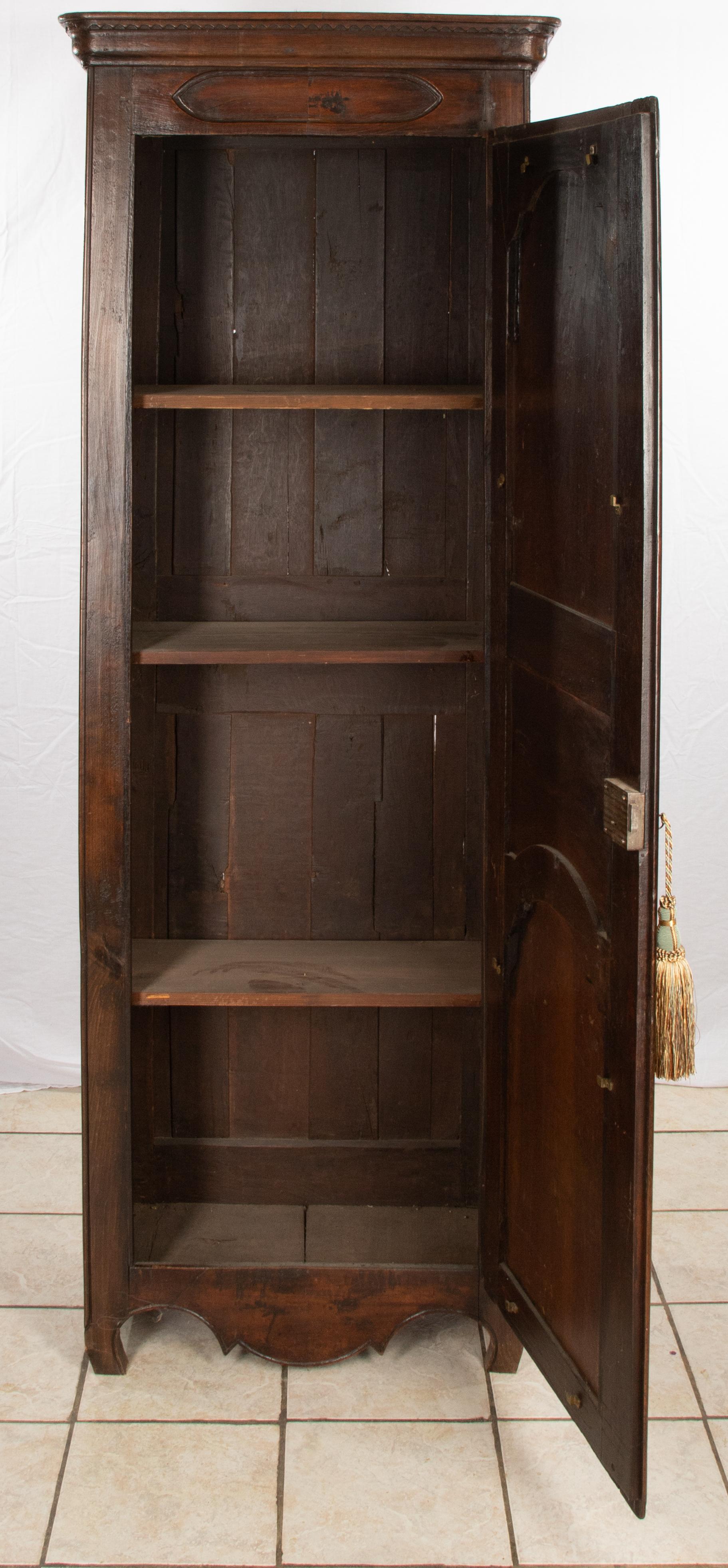 Offering this magnificent single door French walnut armoire. Very simple lines make this a standout piece. Stained in a dark tone. It is a narrow and tall piece.