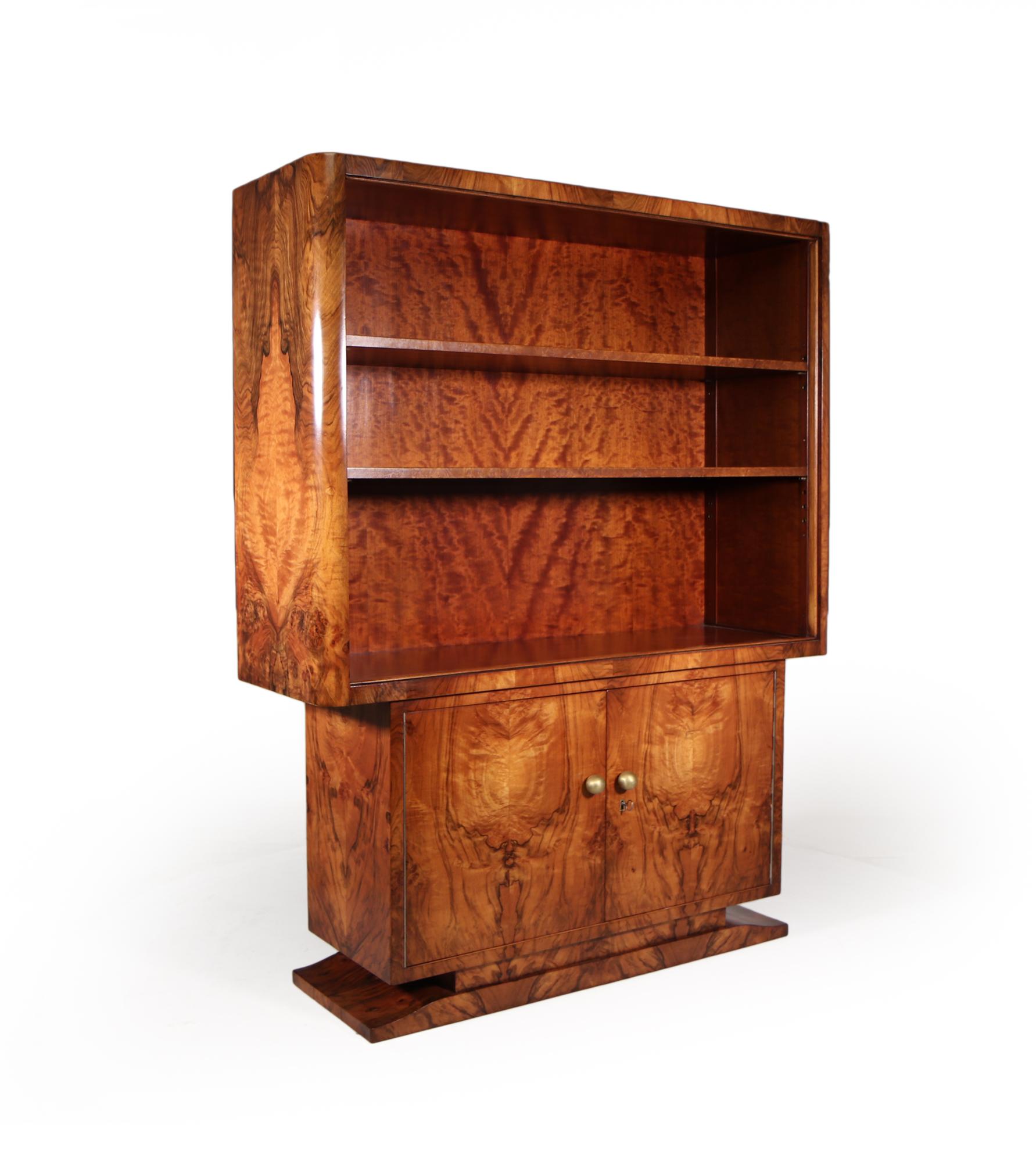 An unusual art deco open bookcase with cupboard below, produced in France in the 1920’s two adjustable shelves in the top section and split sections behind the lockable doors, beautifully figured walnut with a great colour the cabinet has been