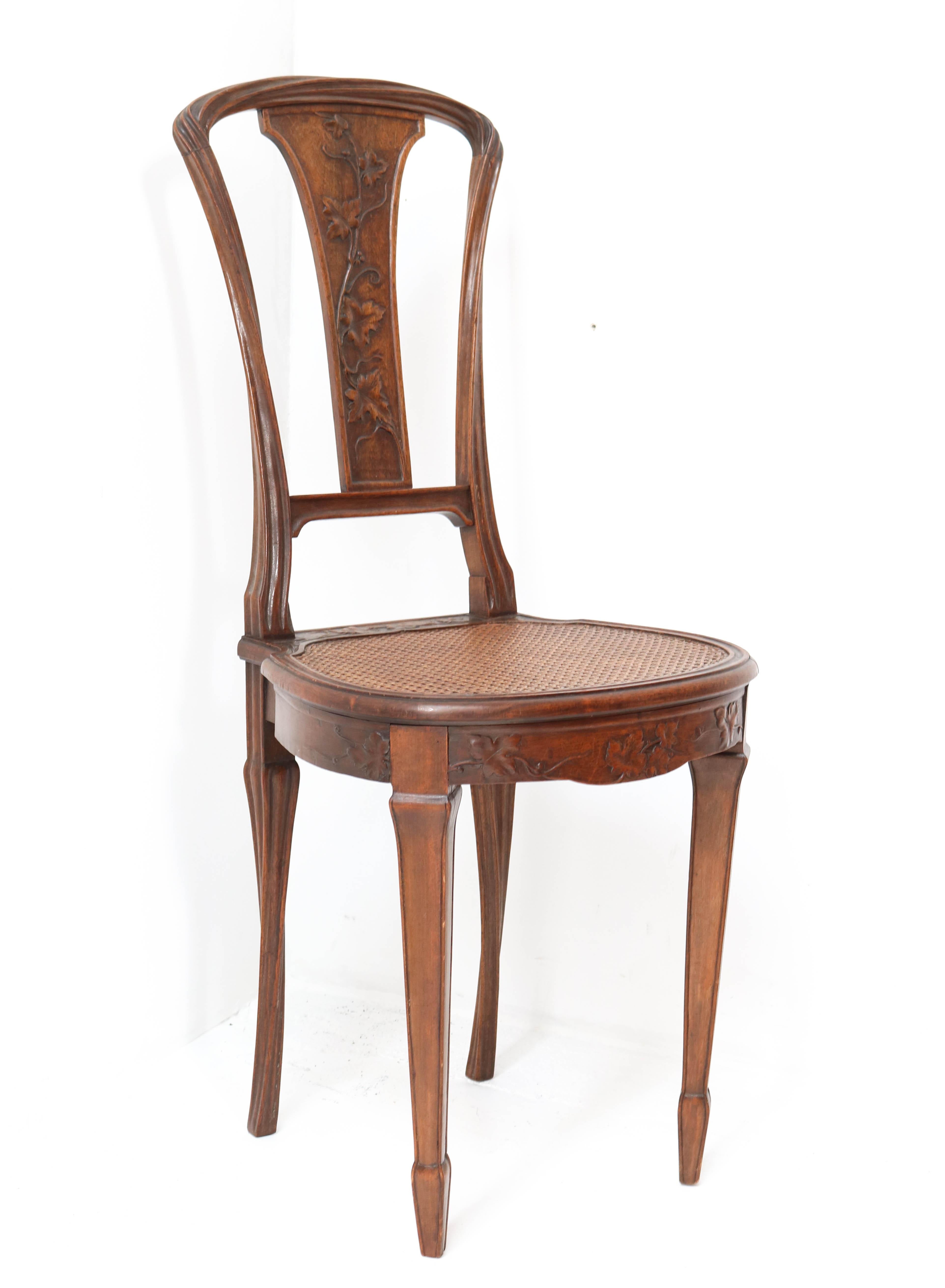 Magnificent and rare Art Nouveau side chair.
Design attributed to Louis Majorelle.
Striking French design from the 1900s.
Solid walnut with wonderful hand-carved legs and back.
Original rattan seat without damages!
In very good condition with a