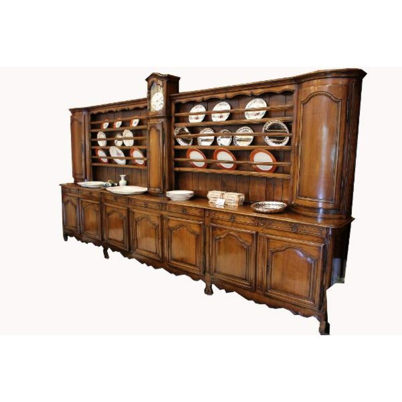 Dieses massive und beeindruckende Buffet aus massivem Nussbaumholz stammt aus einem Kloster in Frankreich und verfügt über eine Uhr mit Schlagwerk und mehrere Ablagen. Die Uhr läutet 5 Minuten vor der vollen Stunde, damit die Mönche Zeit haben, sich
