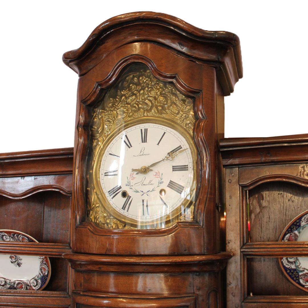Acquired from a monastery in the French countryside, this massive and impressive solid Walnut buffet has a clock that chimes and multiple racks. The clock chimes 5 minutes before the hour so the monks would have time to get to the table. The quality
