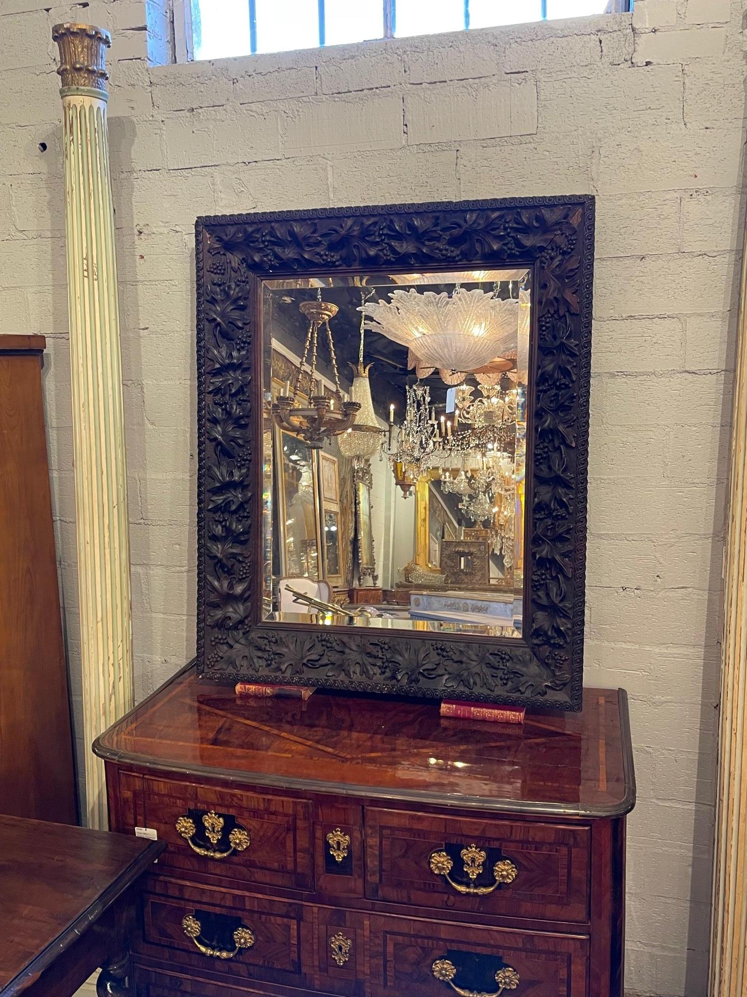 19th century French Carved walnut mirror with original beveled glass, Circa 1880. This a very handsome nicely carved mirror.