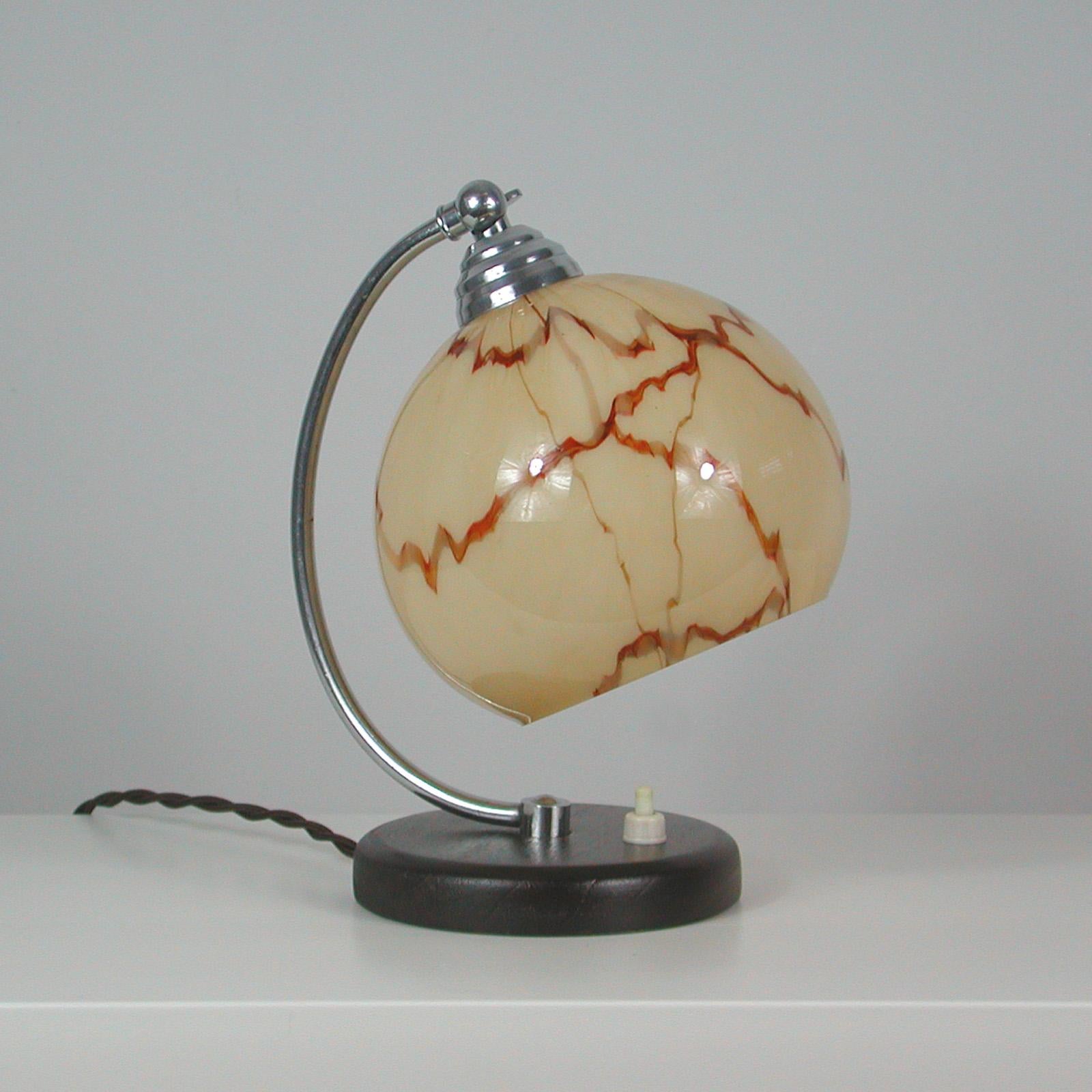 Esta bonita lámpara de mesilla de noche se diseñó y fabricó en Francia durante el periodo Art Déco inspirado en la Bauhaus. Presenta una base de nogal, herrajes cromados y una pantalla ajustable de cristal opalino color crema con decoración