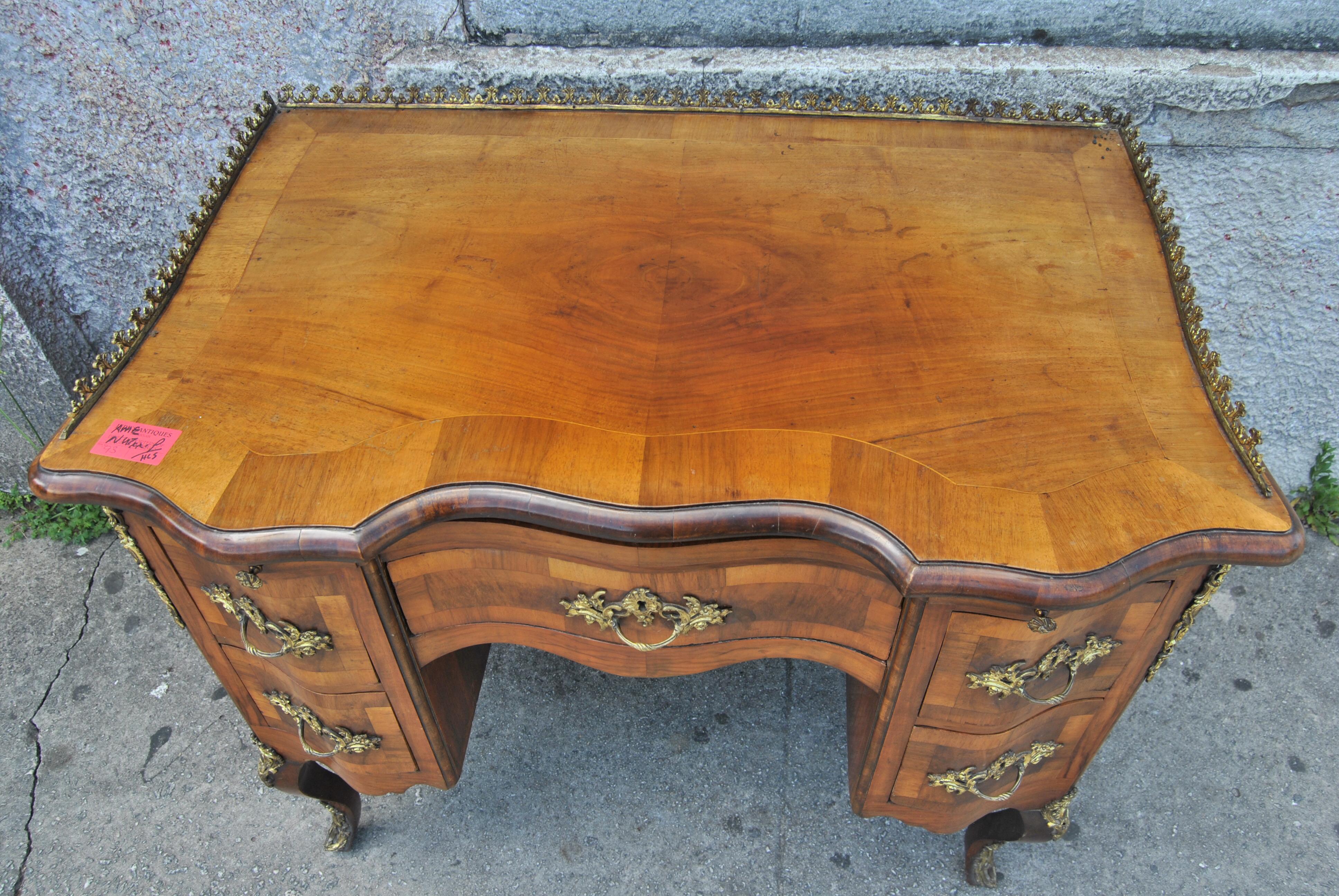 This is a desk / writing table / dressing table / side table made in France, circa 1910. The top is beautifully shaped and has cross cut molding. There is a fabulous pierced Brass Gallery on the right and left sides and on the back of the top. The