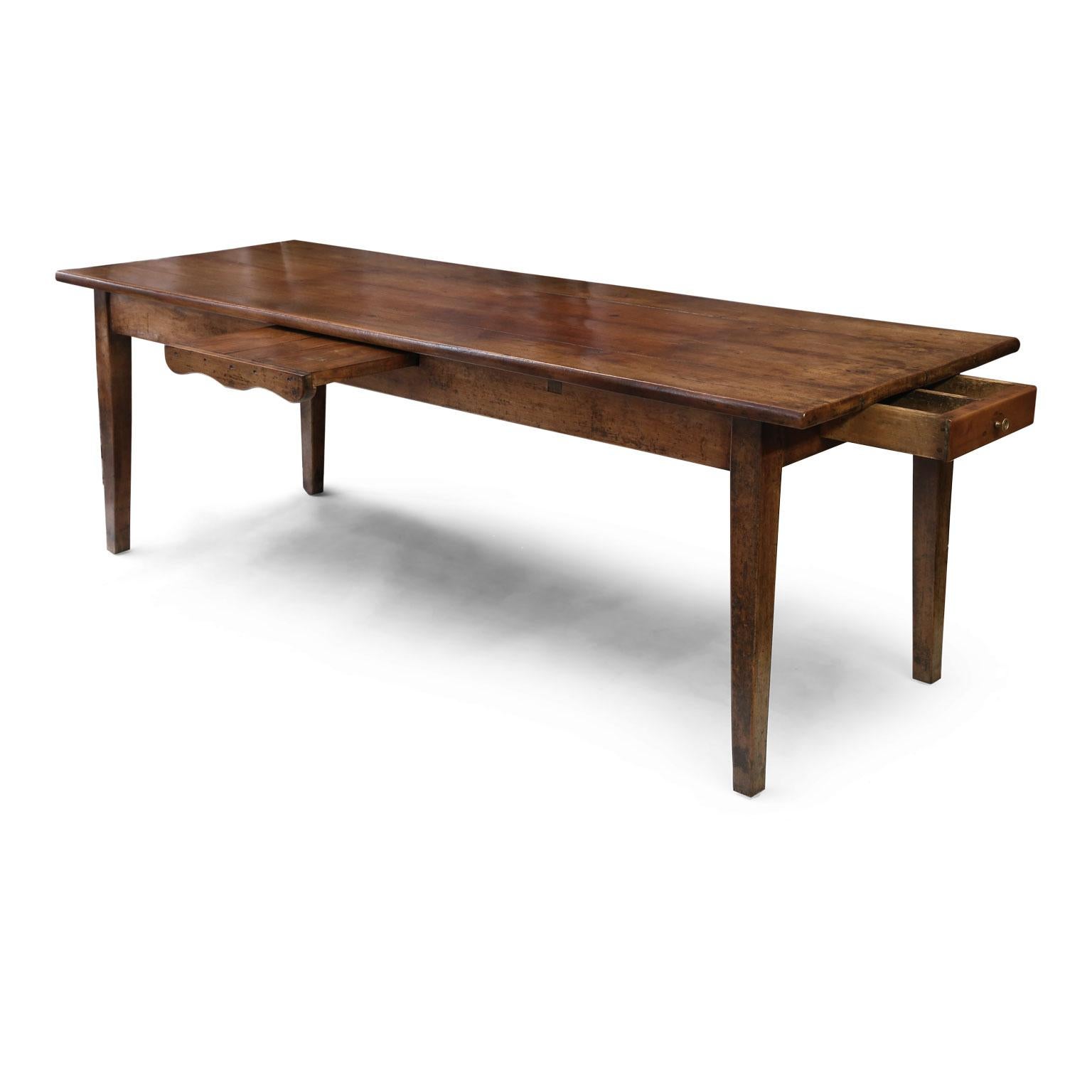 French walnut dining table, originally used as both a dining and work table on a farm. Drawer opens at one end and a cutting board pulls out from the side of table. Constructed circa 1850-1880 from walnut with mortise and Tenon joints this table is