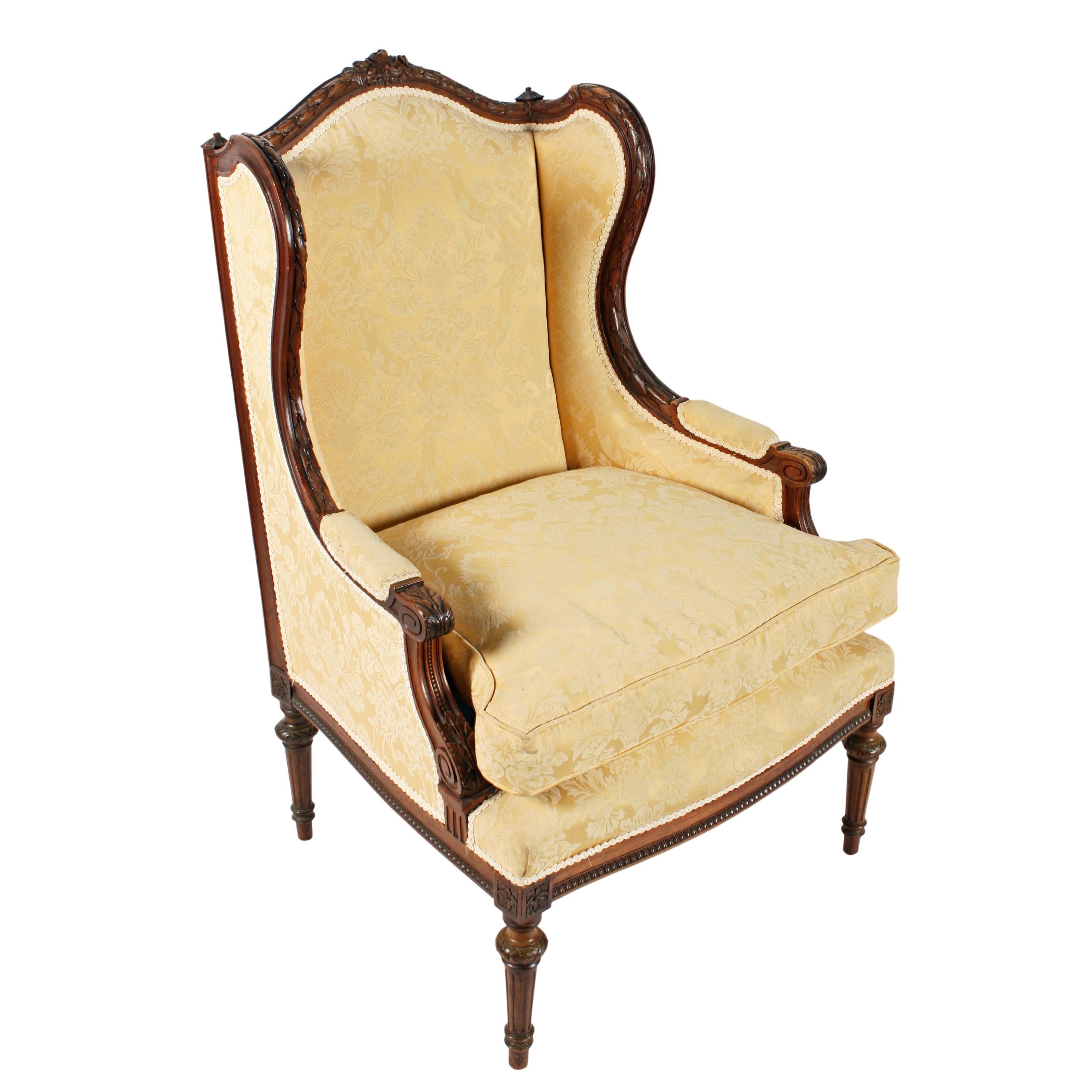 A late 19th century French carved walnut fauteuil or armchair.

The chair has a high winged back with a carved frame with a domed to rail that is decorated with carved roses and ribbons.

The upholstered arm rests have a carved scroll hand rest
