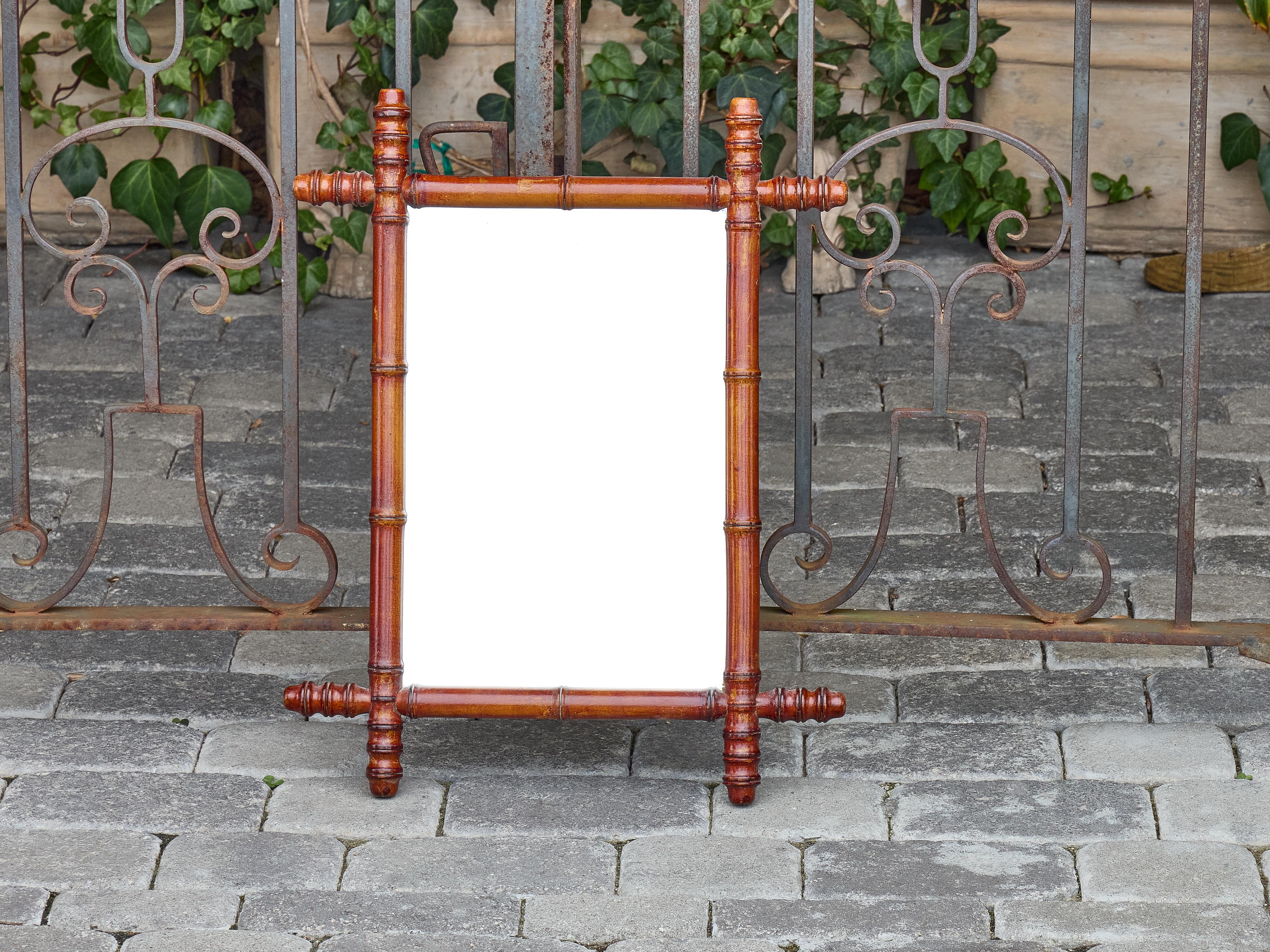 Fabriqué en France vers 1900, ce miroir en faux bambou présente un cadre en noyer finement sculpté et des embouts tournés qui lui confèrent une touche architecturale distinctive. Le cadre imite la structure segmentée du bambou véritable, un motif