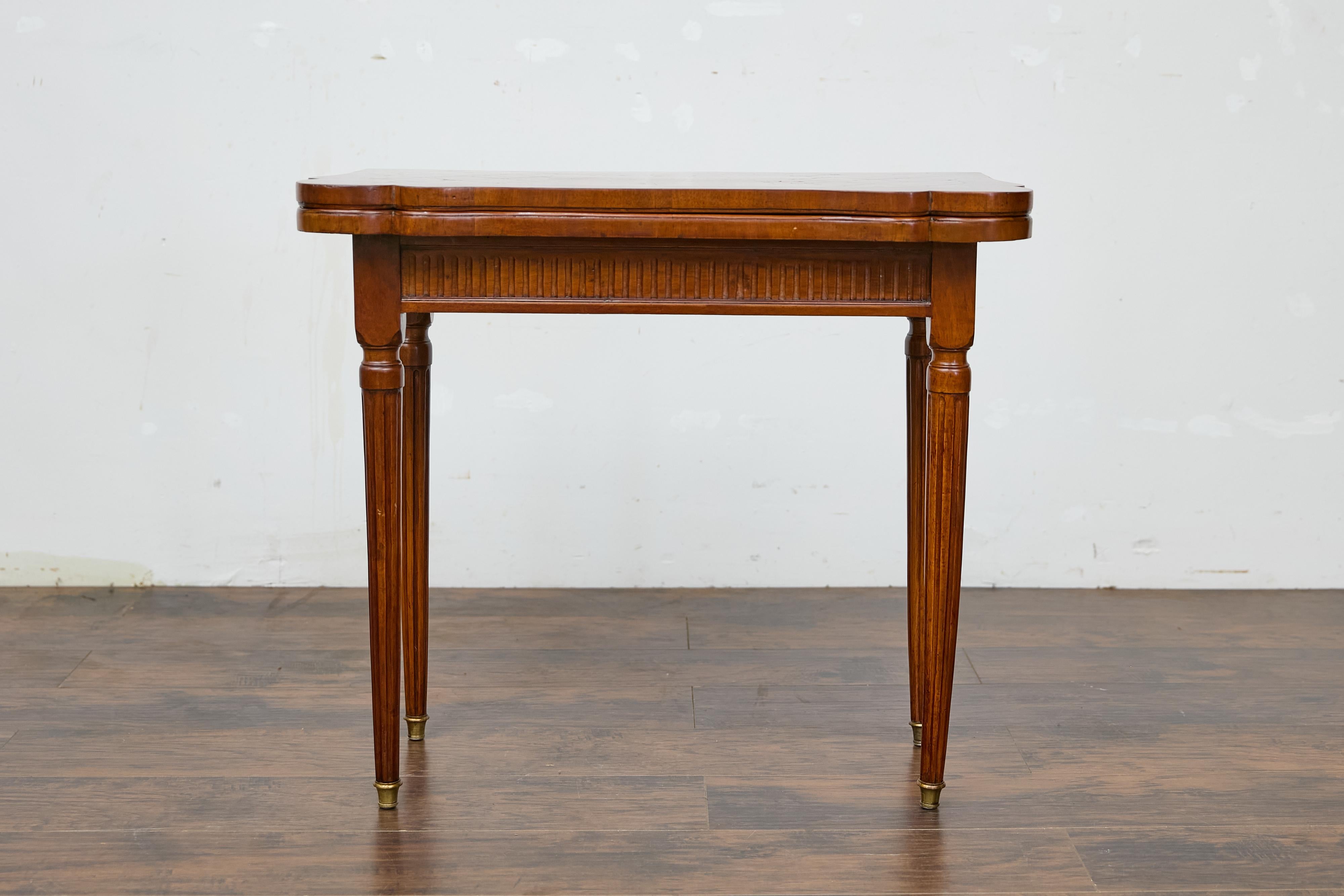 A French walnut game table from circa 1880 with marquetry and felt reversible folding top. This French walnut game table from circa 1880 captivates with its exquisite craftsmanship and versatile design. Featuring a reversible folding top, the table