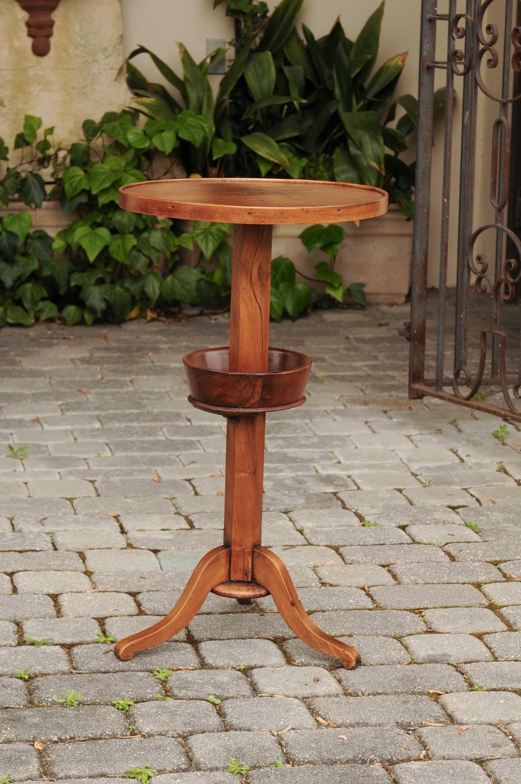 A French walnut guéridon side table from the late 19th century, with circular top and tripod base. Born in France a few years after the collapse of the Second Empire, this exquisite walnut guéridon features a round planked top, resting on an