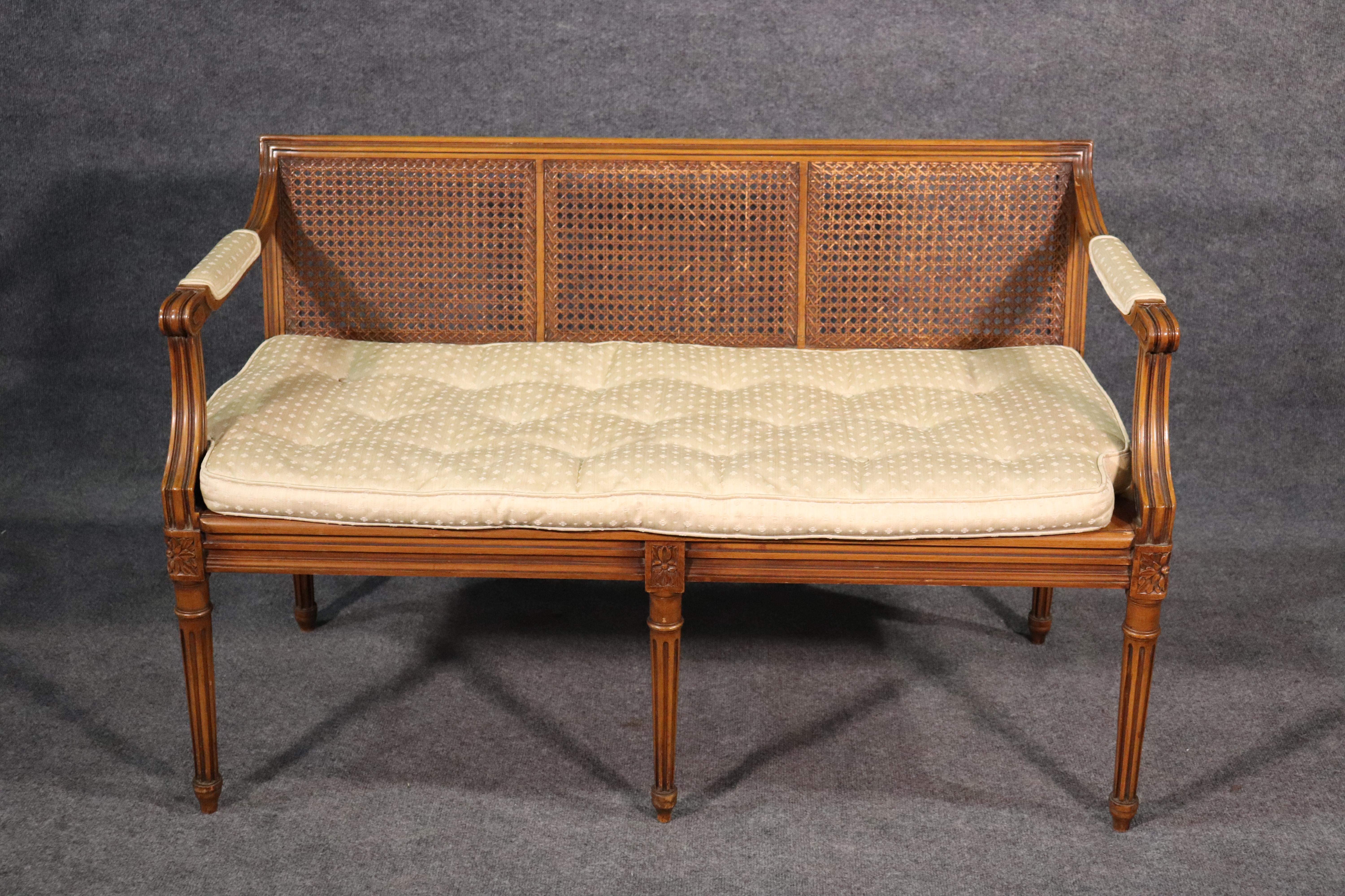 This is a beautifully simple Louis XVI settee with good cane surfaces and seating and a goose feather cushion, circa 1940. The settee shows no cane damage and is in good overall vintage condition. 

The settee measures 29.5 tall x 46.5 wide x 22