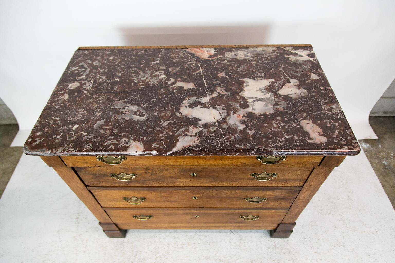 This French walnut marble-top chest has the original bull nose marble top which has a one-inch wooden retaining strip at the back. The top drawer has a 1/2inch overhang over the three lower drawers. The brass keyhole escutcheons are original, but