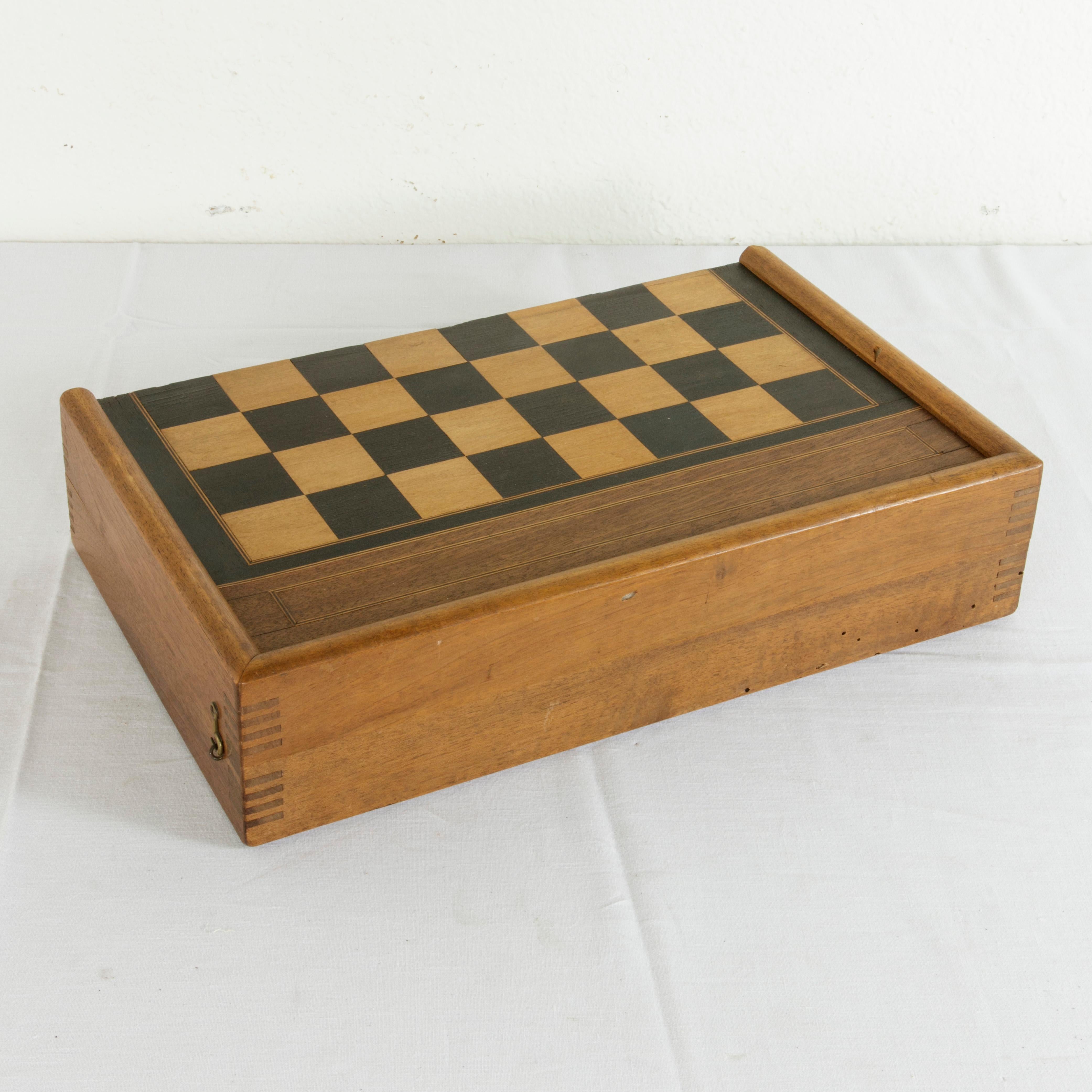 This French walnut marquetry folding game box from the turn of the 20th century is for both checkers and backgammon. It is finely constructed with dovetailed corners, inset hinges, and a locking brass hook on each side. The checker board side of the