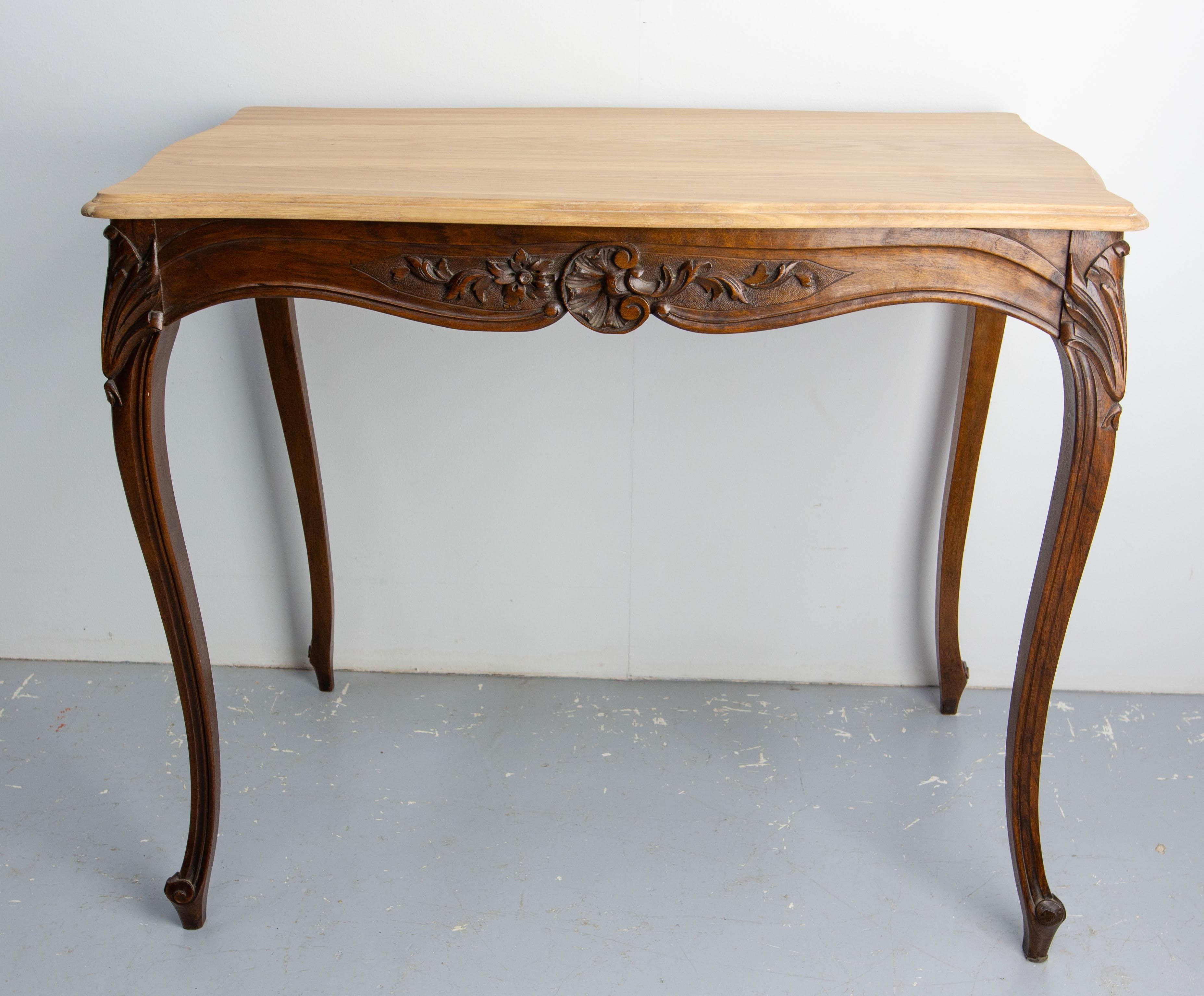 Antique Walnut side table, made circa 1900 in the Louis 15 style.
To add a drawer while keeping the aesthetic appearance of the table, a large drawer is hidden behind the sculpture of the front belt of the table.
The top table was redone with the