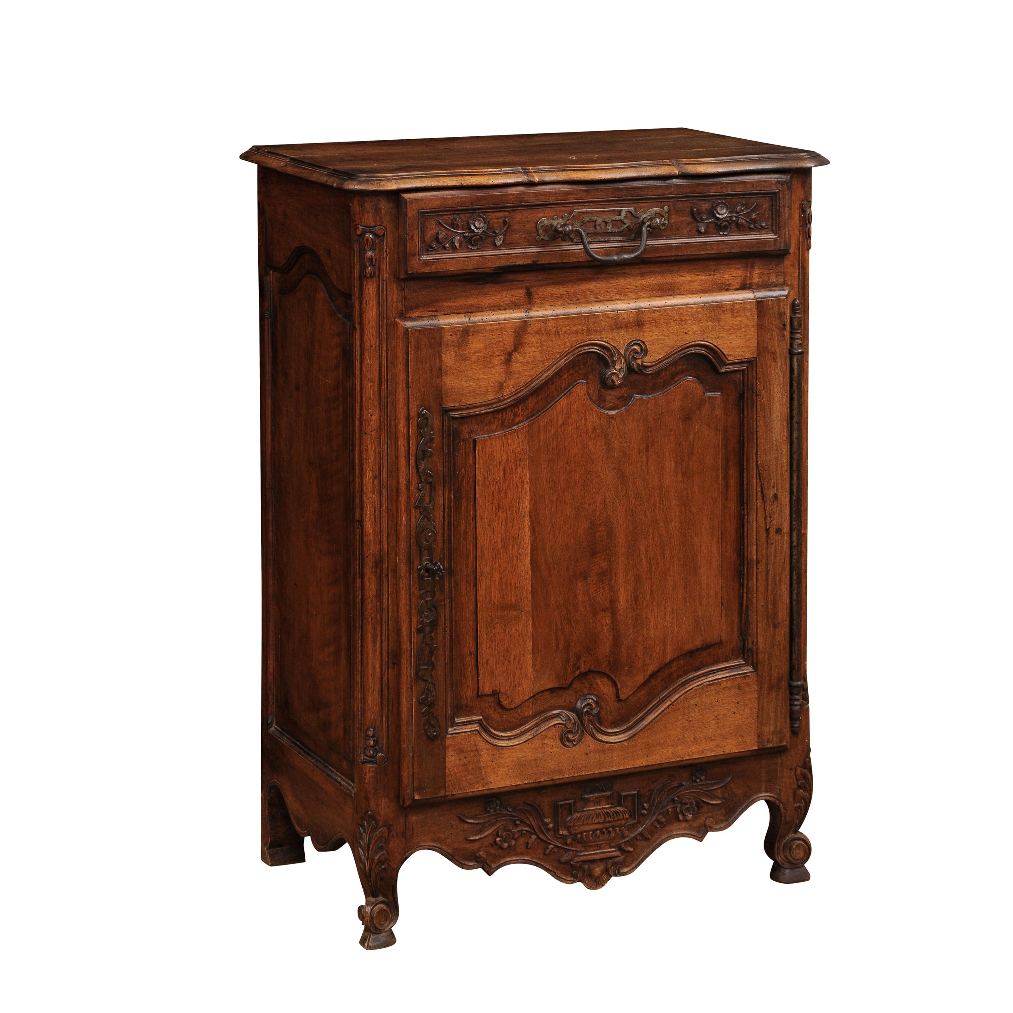 A French walnut confiturier from Provence with single drawer and single door, carved floral décor with vase. Embrace the charm of Provence with this delightful French walnut confiturier from the region. Crafted with care and adorned with exquisite