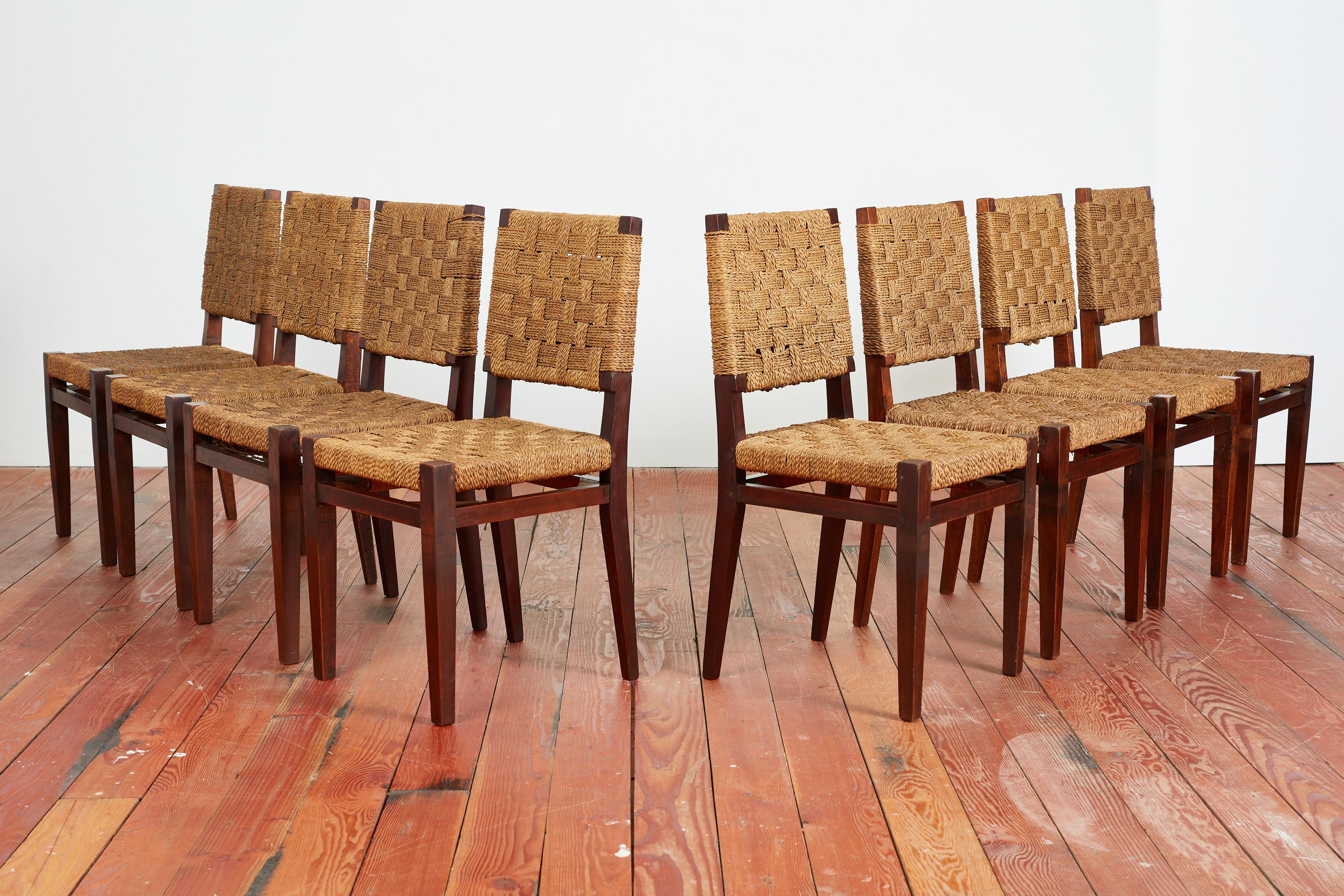 Beautiful set of 8 French walnut and rope dining chairs in the style of Audoux Minet  - 
France, 1960s 
Sleek angular walnut legs with rope woven seats and backs 
