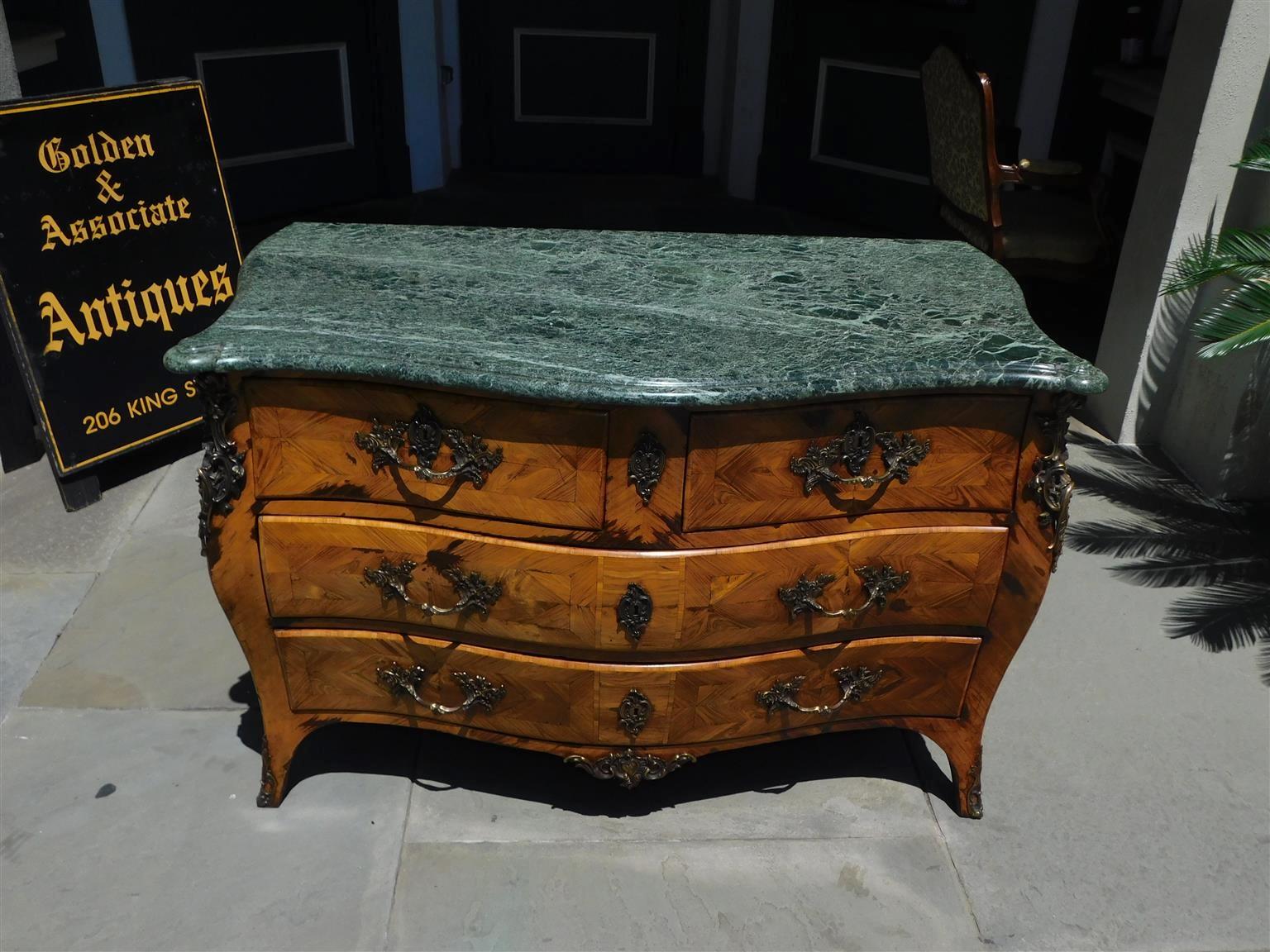 French Walnut serpentine graduated chest of drawers with exquisite decorative inlays, original ormolu mounts , original greenish white vane marble top,  and terminating on french splayed feet . All Original .  Mid-18th Century.