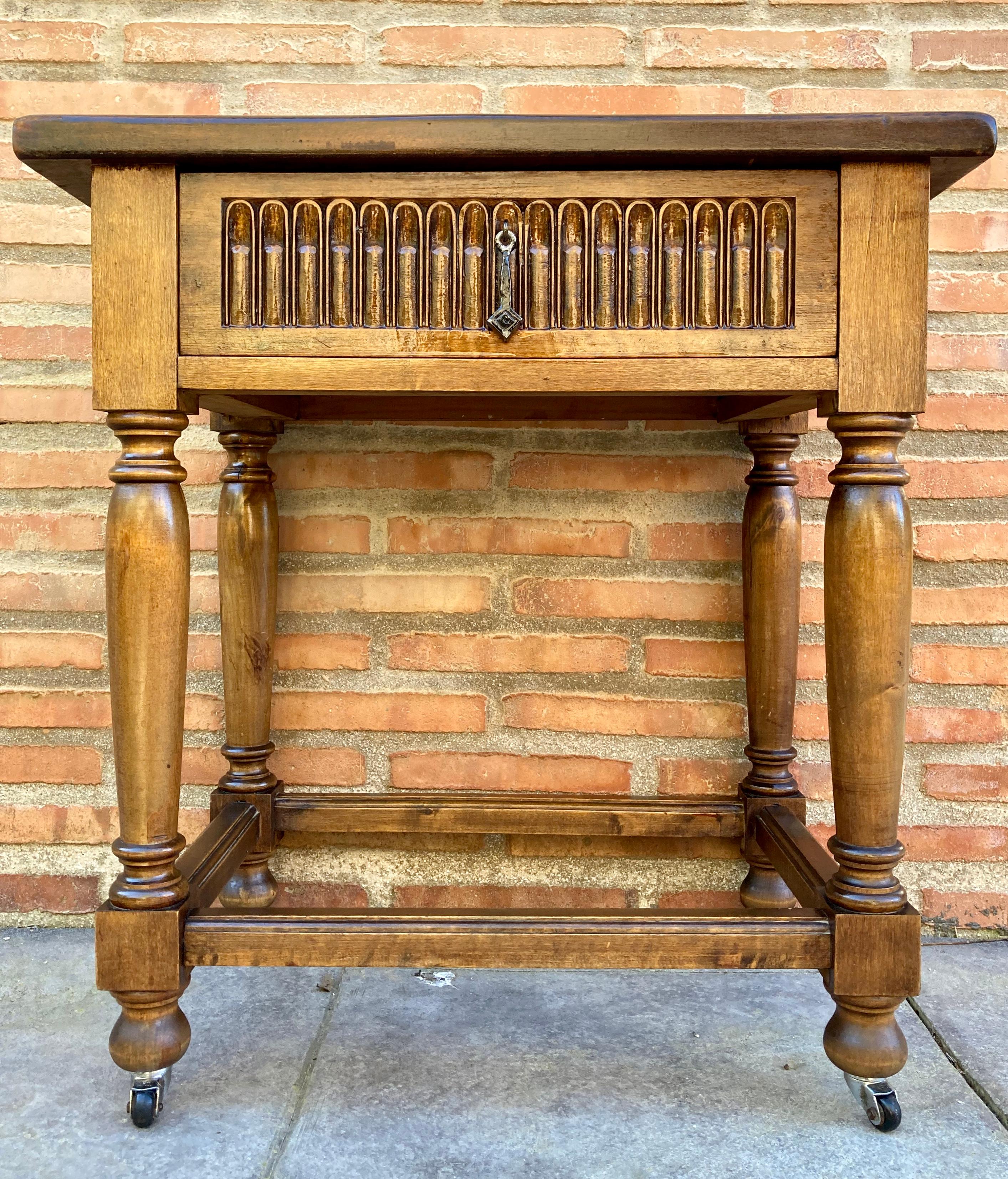 Late 19th century French walnut side table, with one drawer, decorated with arches and column legs on wheels. Born in France during the last years of the 19th century, this beautiful walnut side table has a rectangular top, placed on a single