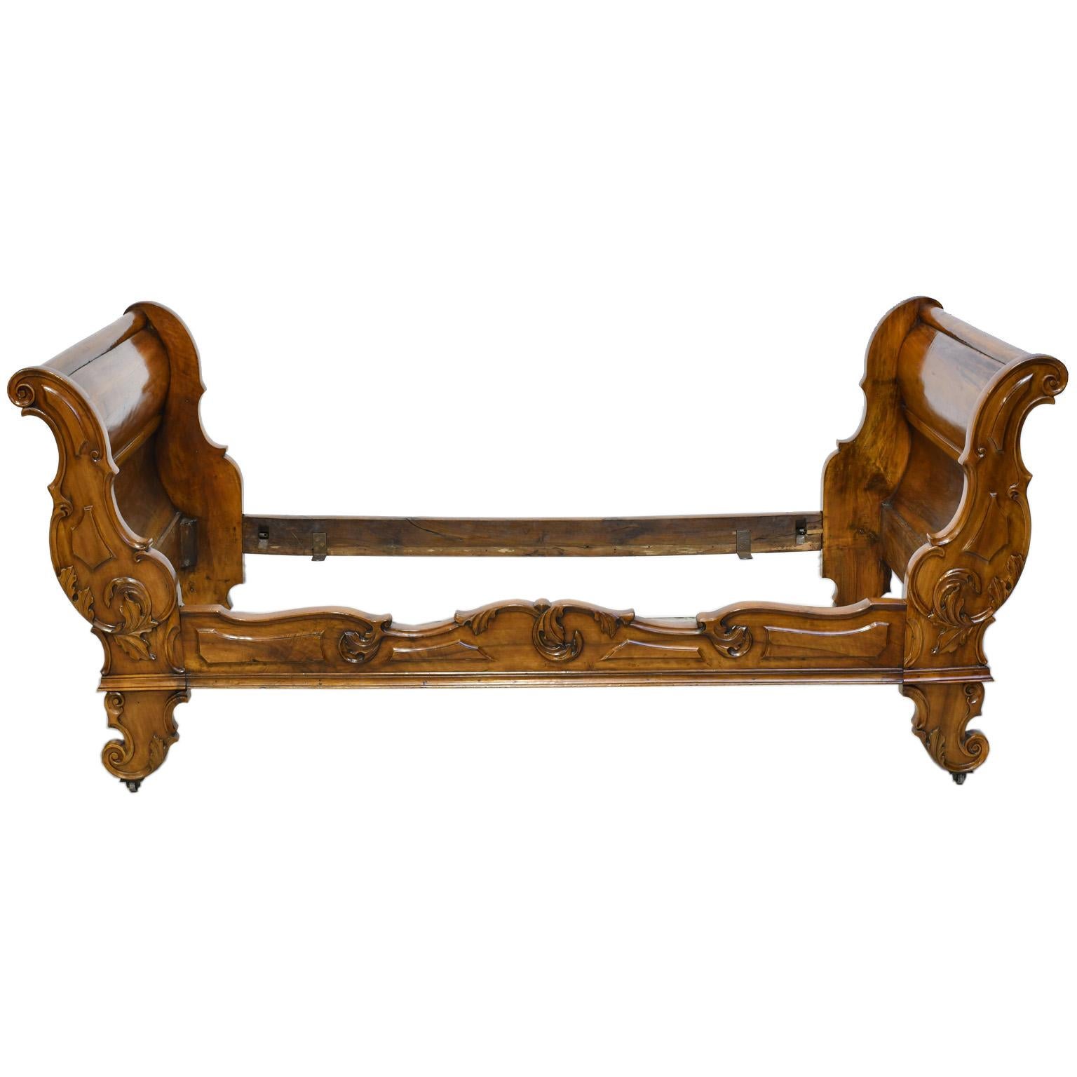 Exceptional French sleigh bed in solid French walnut, circa 1840. There are no appliqué's, headboard, footboard and side rail are carved from solid walnut. Carvings are well articulated, lively and expressive. Bed has been restored in our workshop