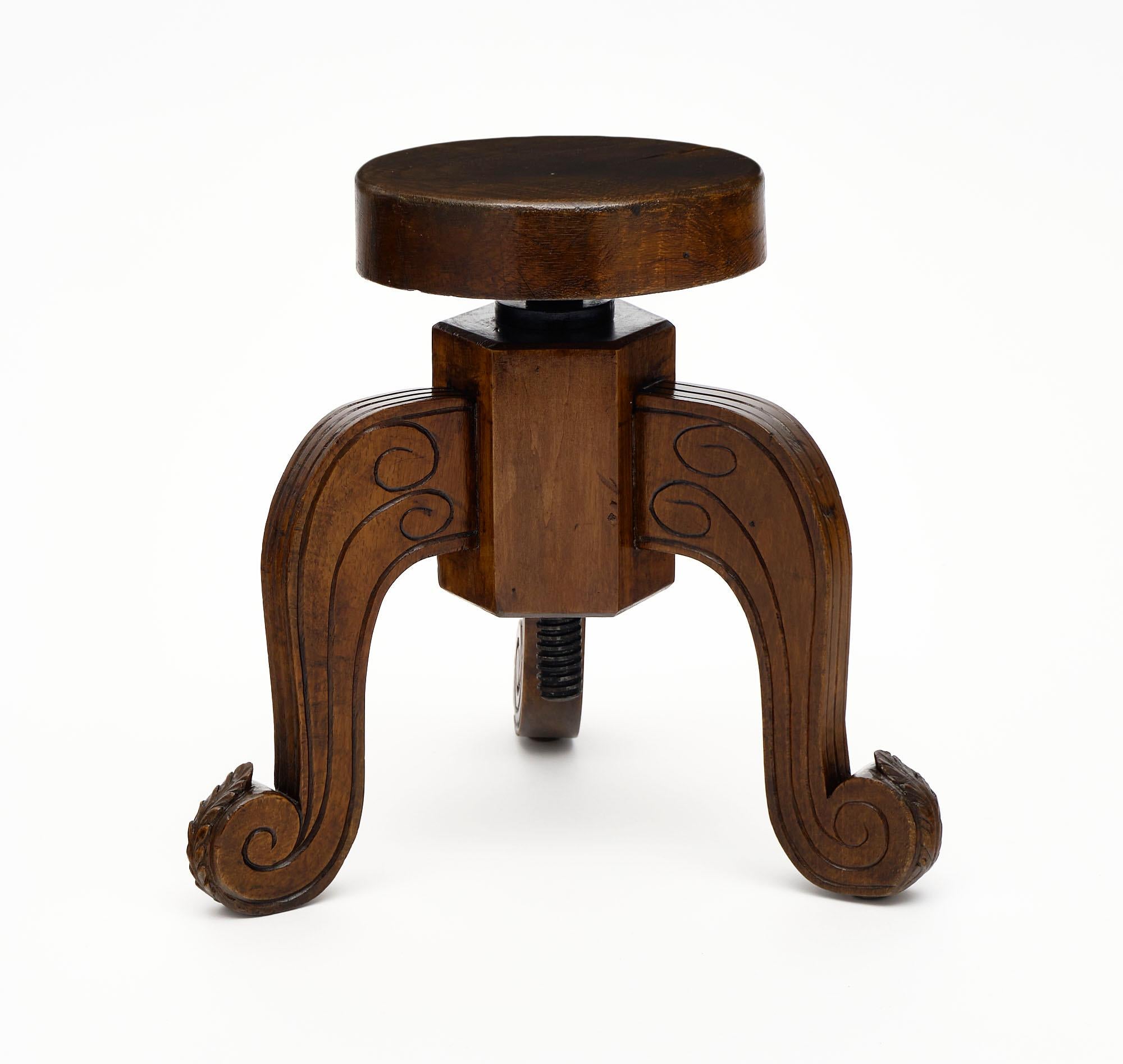 Stool with hand-carved detail and made of walnut. The seat turns to raise or lower as needed. We love the curved details and warmth of the waxed, antique wood.