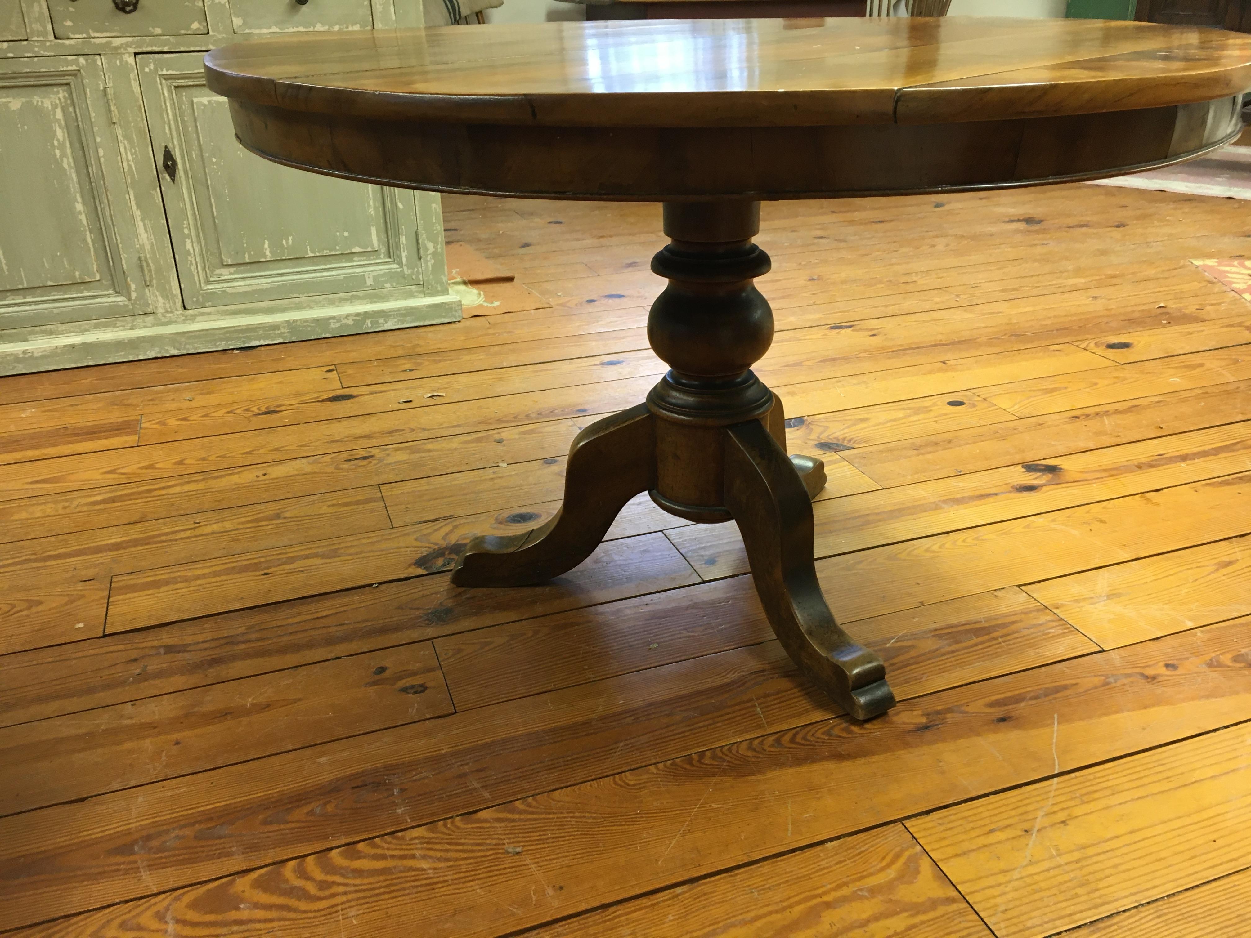 This is a walnut table, which is a tilt top. That means it was used as a wine tasting table and was moved against the wall when not in use. The patina is the best you will ever find and plenty of room for chairs because of the pedestal base.