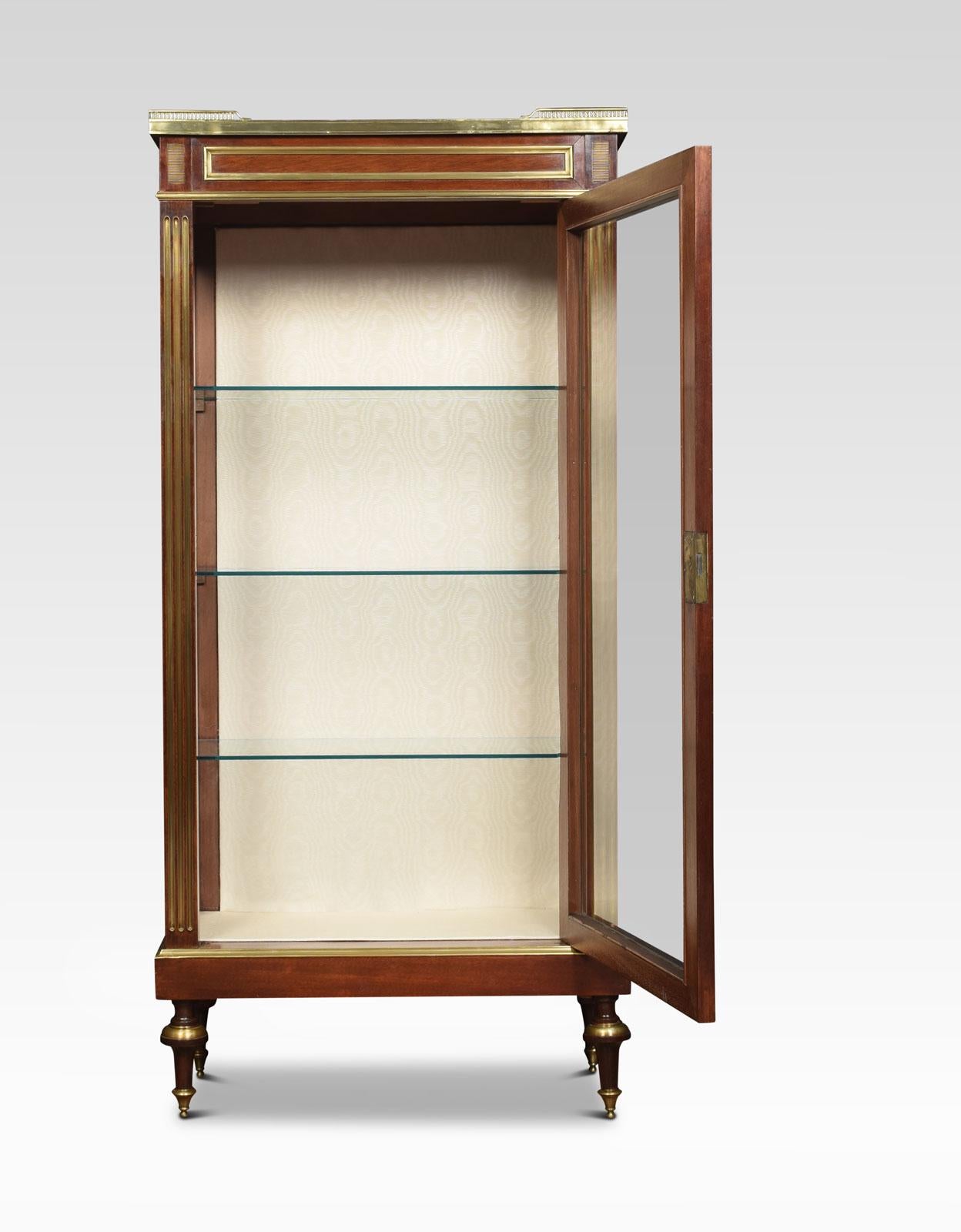 French walnut vitrine cabinet the raised three-quarter brass pierced gallery enclosing marble top. To the large single door opening to reveal shelved interior and upholstered back and base. Flanked by gilded reeded columns. All raised up on brass