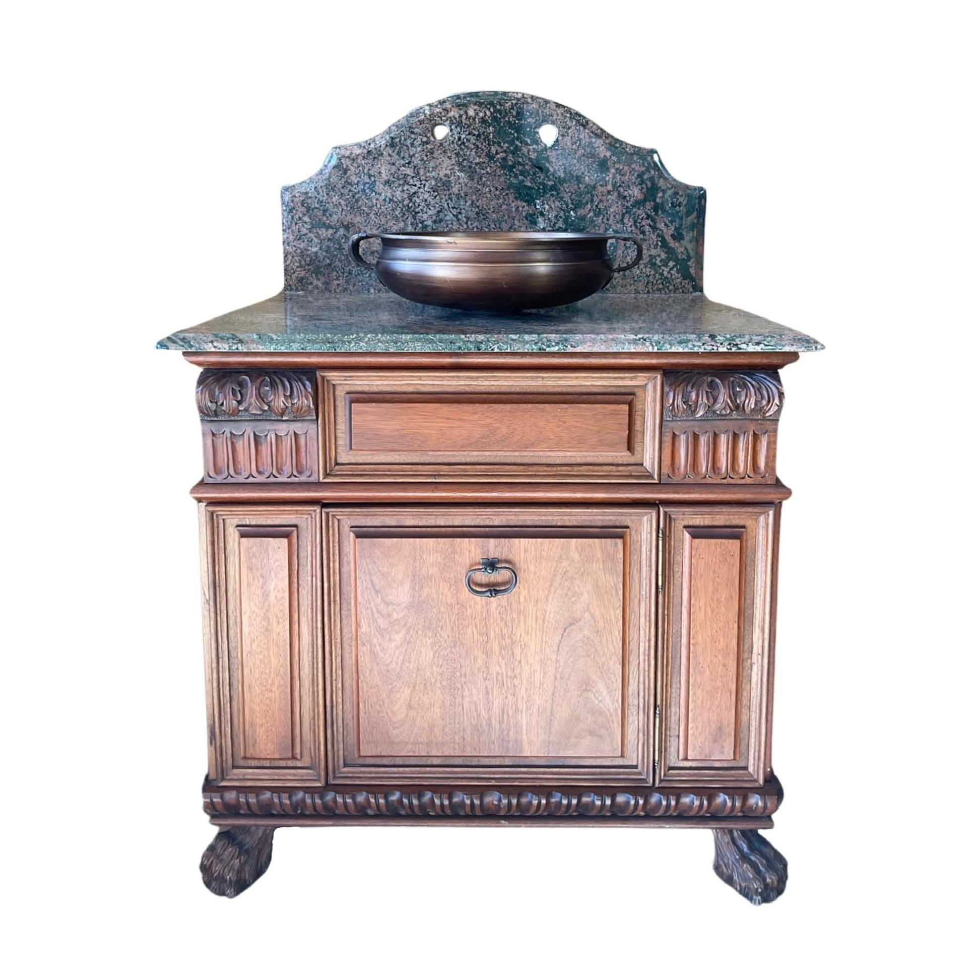 This French-made sink combines contemporary design with classic style. The bottom base is crafted with walnut wood, while the top and backsplash are made from polished marble. Delicate carvings, copper accents, and a unique hardware set complete the