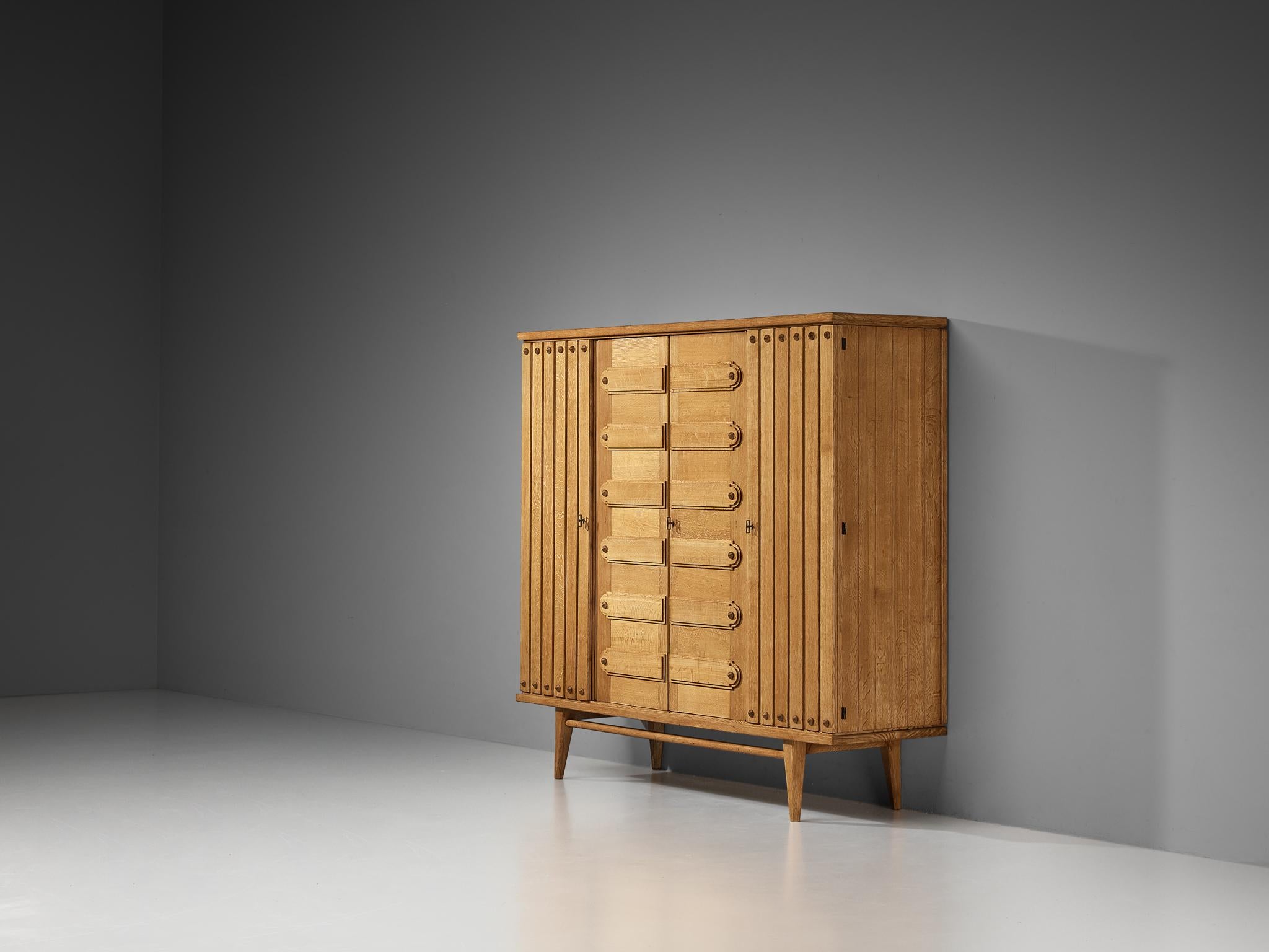 Vanity, high board or armoire, brass, France, 1960s

French large cabinet or wardrobe made in oak with beautiful grain and detailing. With the vividly designed fronts and the functional and versatile storage facilities this high-quality piece of