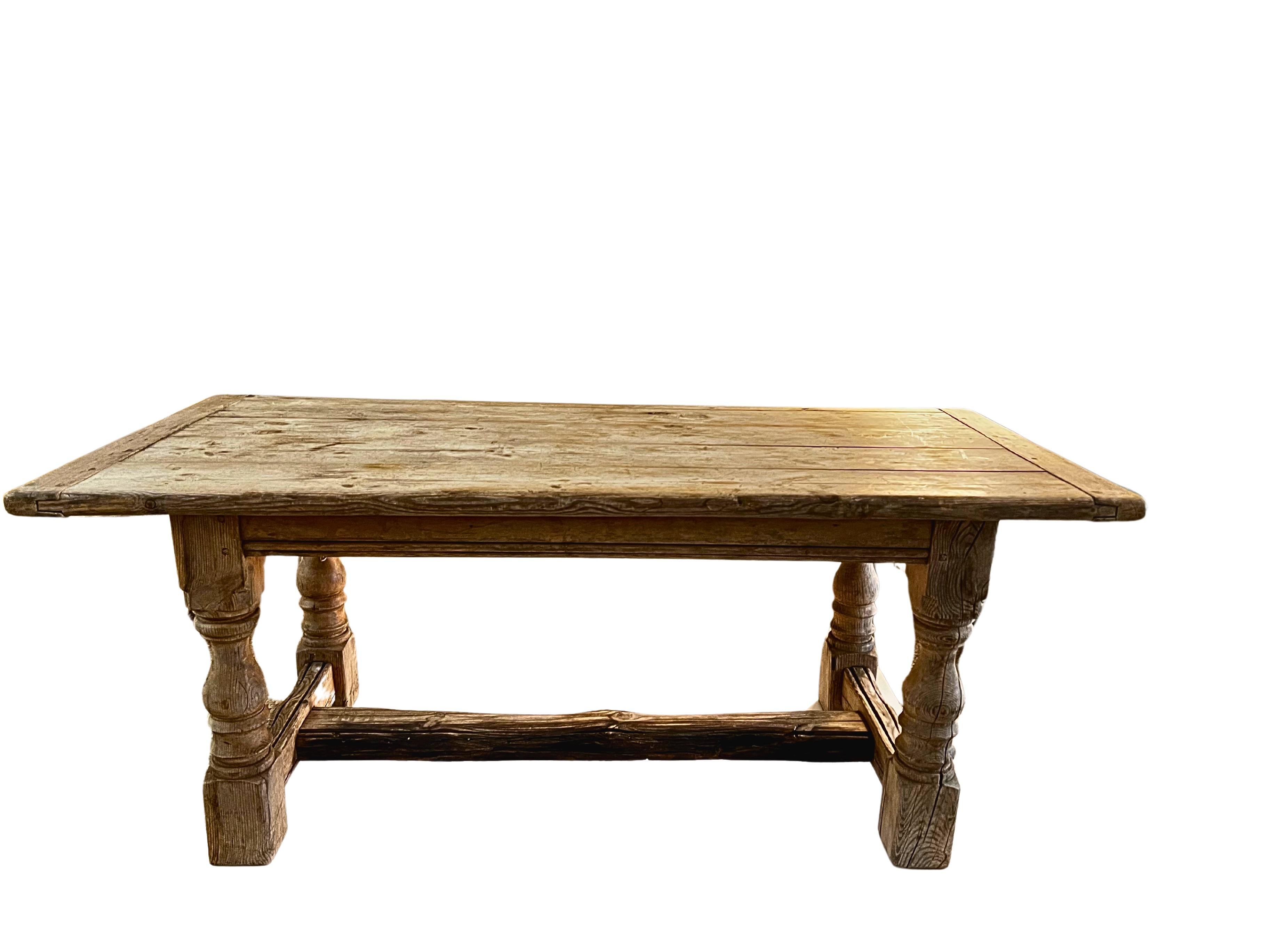 A French Farmhouse Table with turned legs, crafted from weathered oak for a rustic yet elegant look. Spacious and sturdy, it's perfect for gathering family and friends.