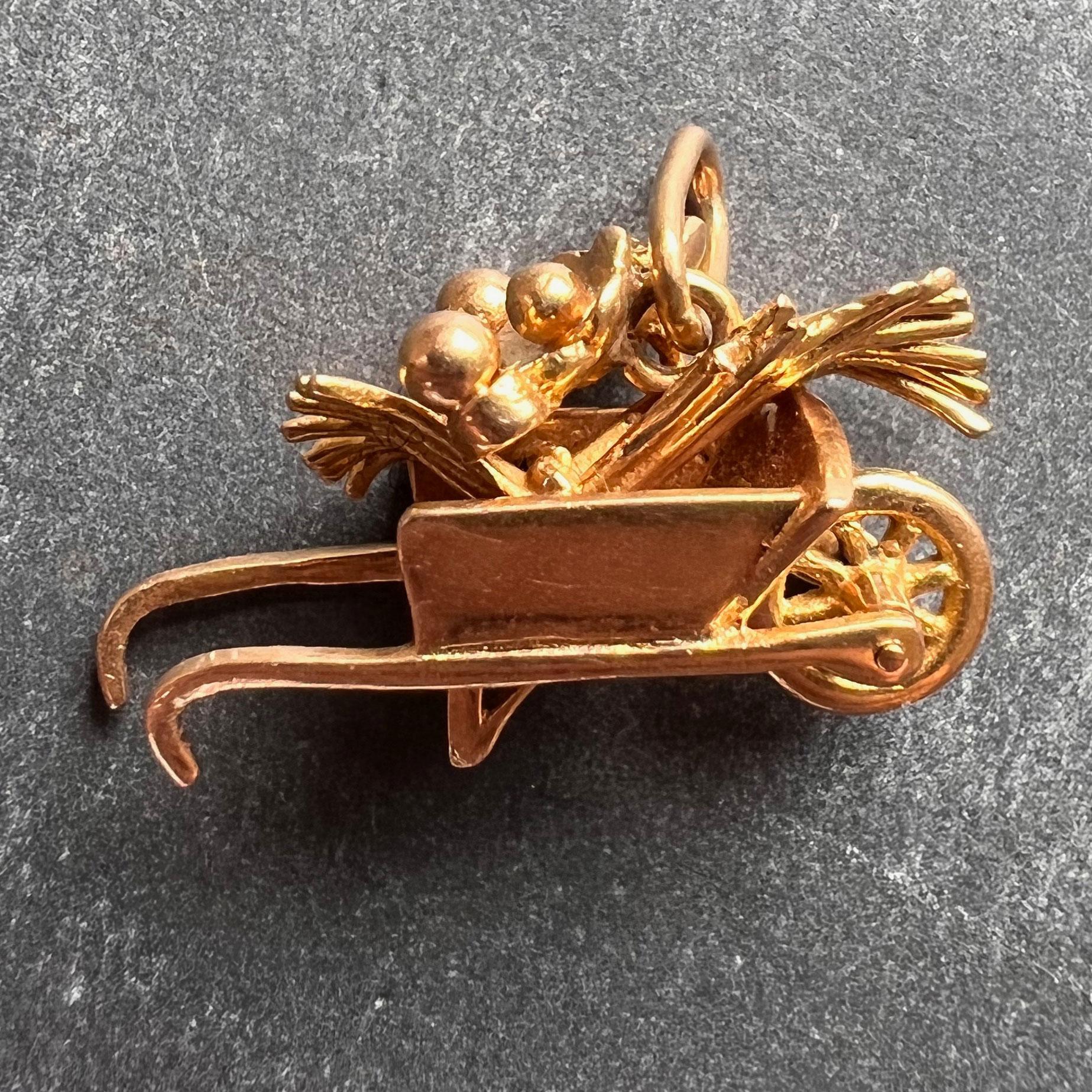 An 18 karat (18K) yellow gold charm pendant designed as a wheelbarrow filled with flowers, with a rotating front wheel. Stamped with the eagle’s head for French manufacture and 18 karat gold and an unknown makers’ mark.

Dimensions: 1.2 x 2.1 x 0.8
