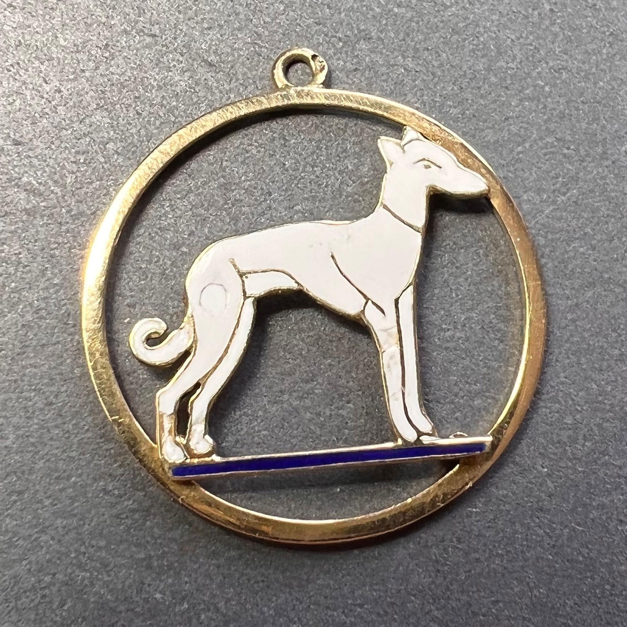 An 18 karat (18K) yellow gold and charm pendant designed as a circle with a white enamel whippet dog standing on a blue enamel ground. Stamped with the eagle mark for 18 karat gold and French manufacture.
 
Dimensions: 2.5 x 2.3 x 0.2 cm (not