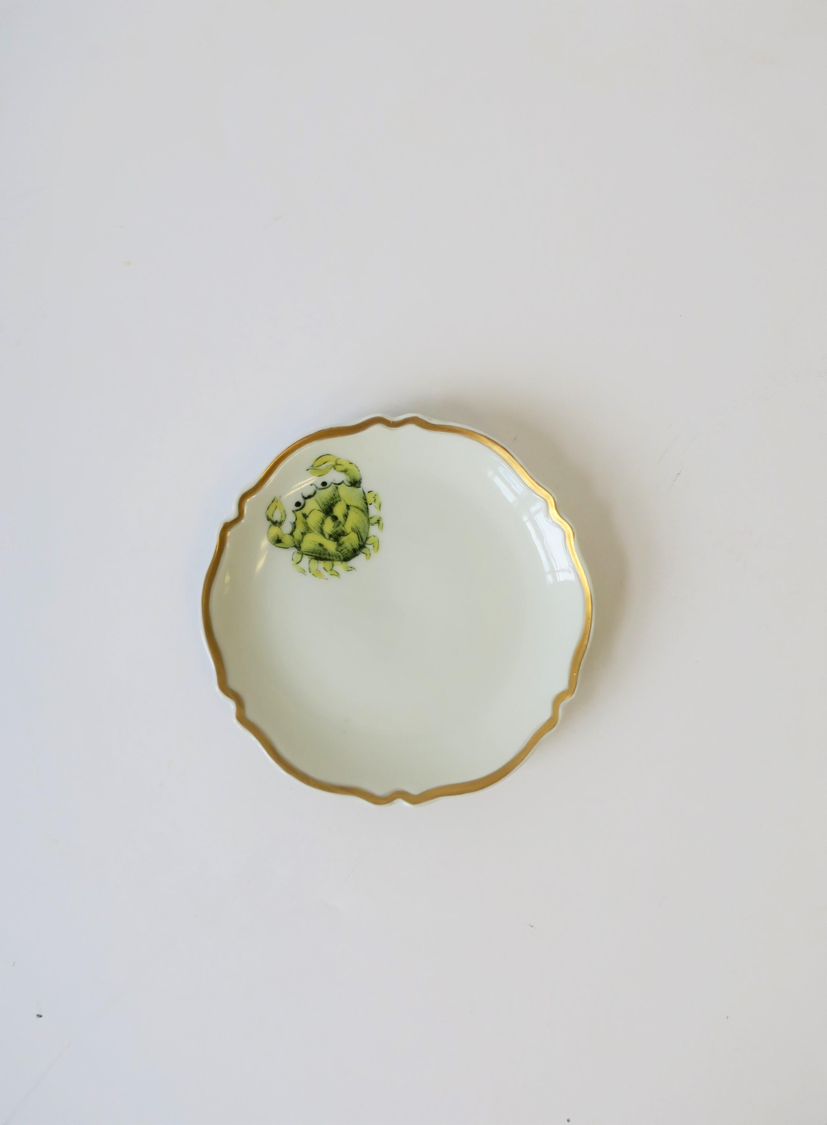 A beautiful midcentury French porcelain white and gold round jewelry dish signed by designer, circa mid-20th century, France. Dish has gold detail around decorative edge, and a decorative 'crab' sea creature or crustacean. All hand-painted. This