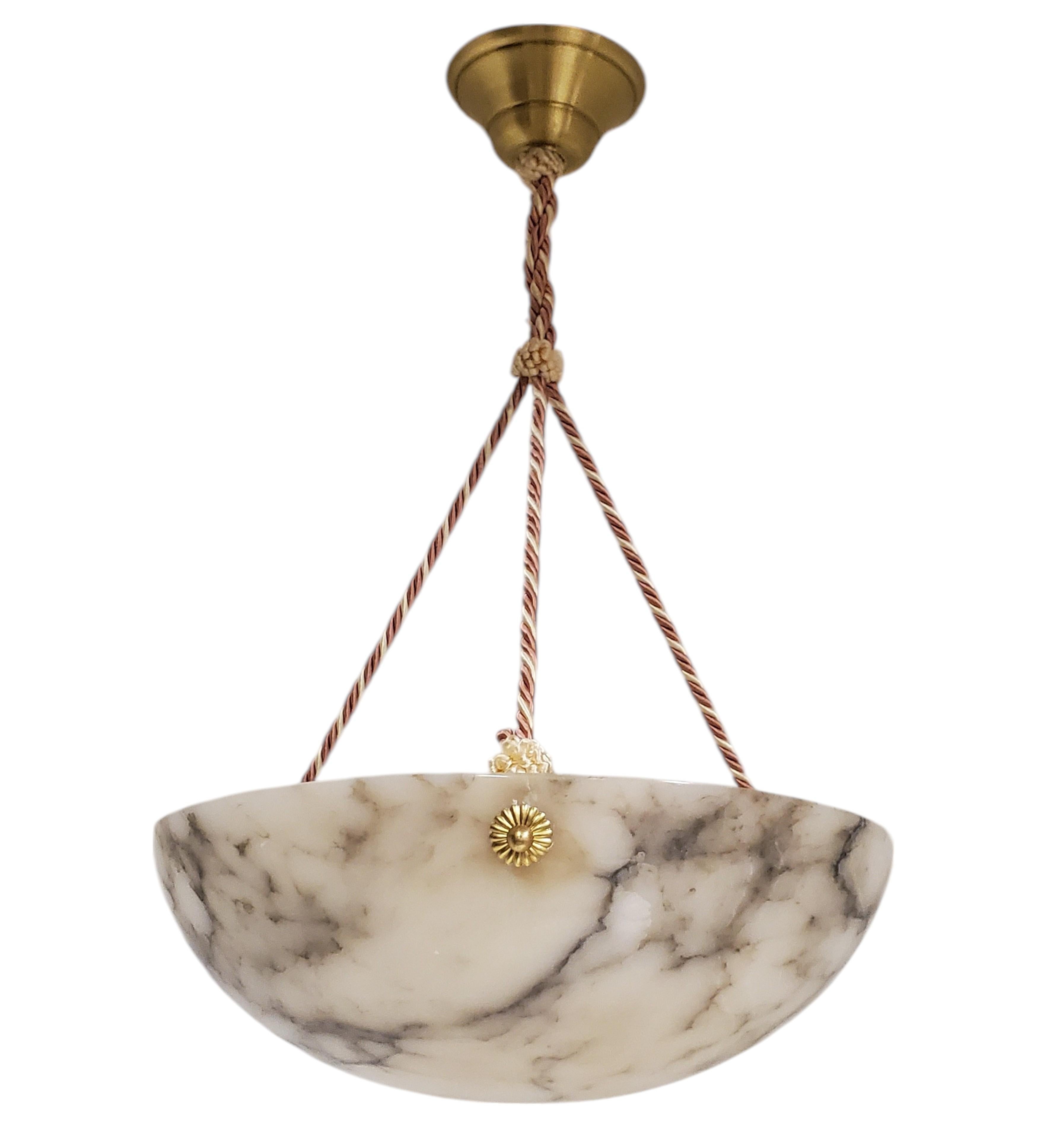 Pendentif en forme de bol en albâtre, de style Art déco français, avec des veines gris clair contrastées et des stries naturelles dans l'ensemble.
La couleur de fond en blanc et la juxtaposition du gris plus foncé créent des motifs passionnants