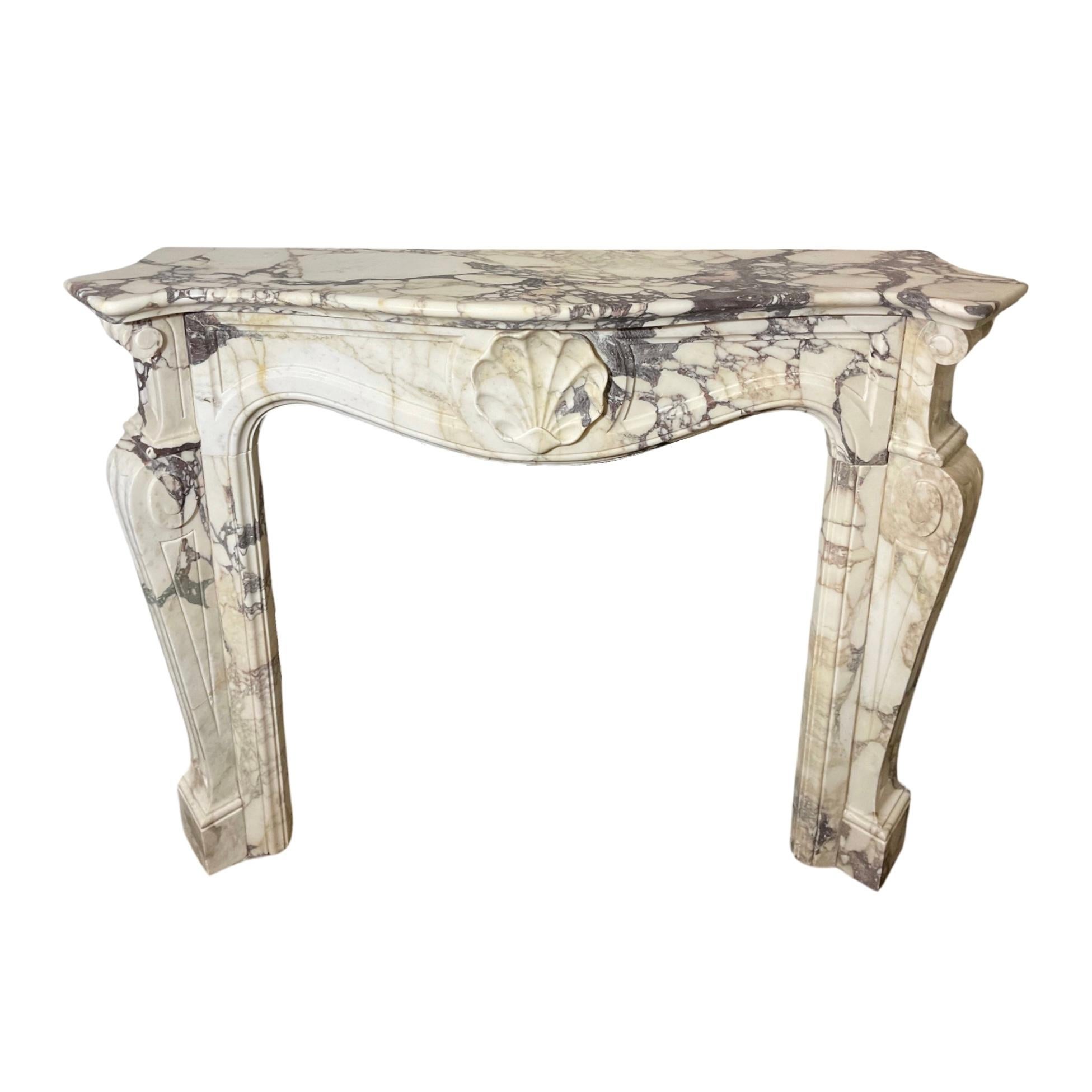 This French white Breche Marble Mantel from the 1850s exudes elegance and sophistication. Crafted in the Louis XVI style, it features a stunning shell carving in the center. Made from high-quality white Breche marble imported from France, this