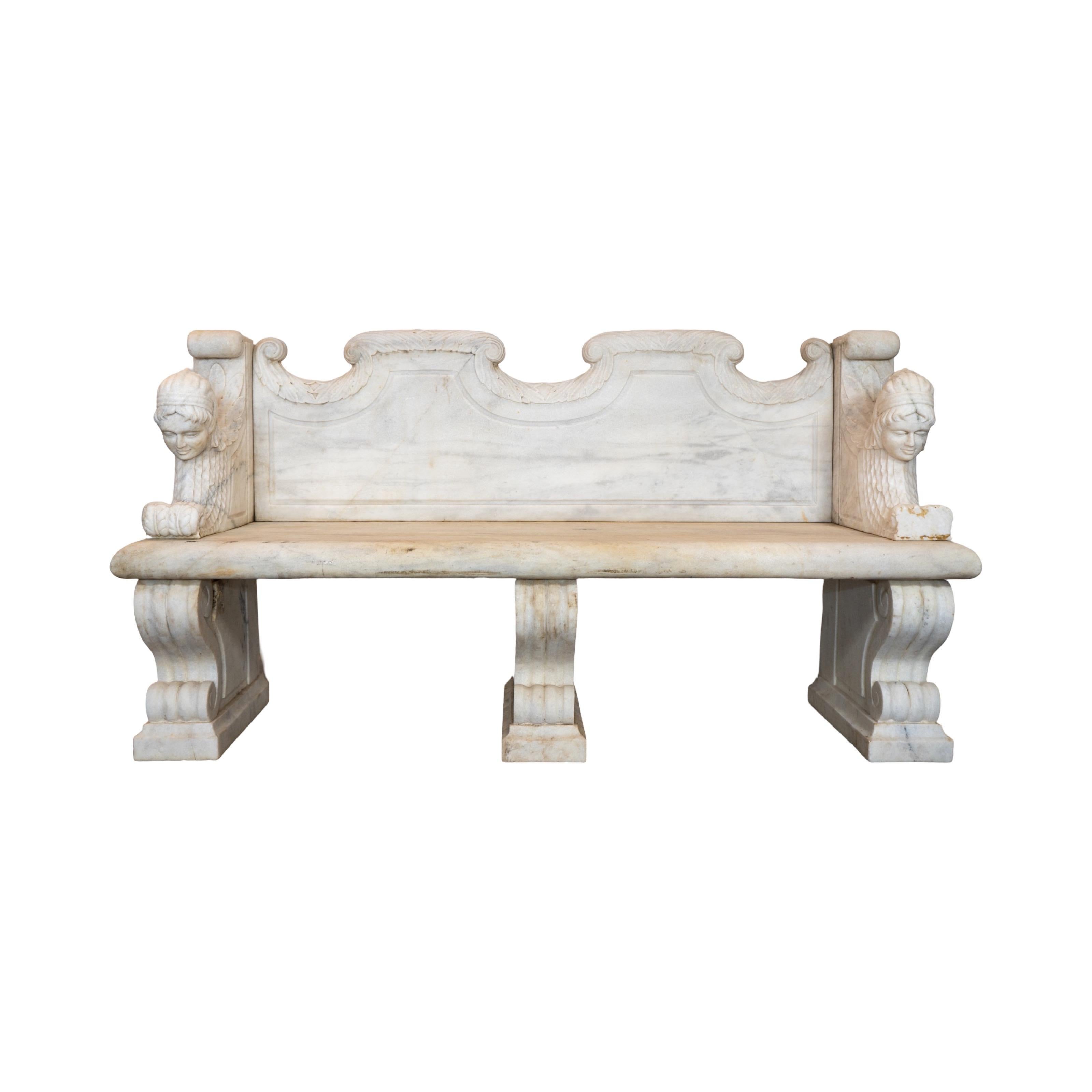 This 18th century French White Carrara Marble Bench is a sophisticated addition to any outdoor space. Made of high-quality Carrara marble, it features intricate carvings of figures on both arm rests. Designed to fit three people comfortably, it's