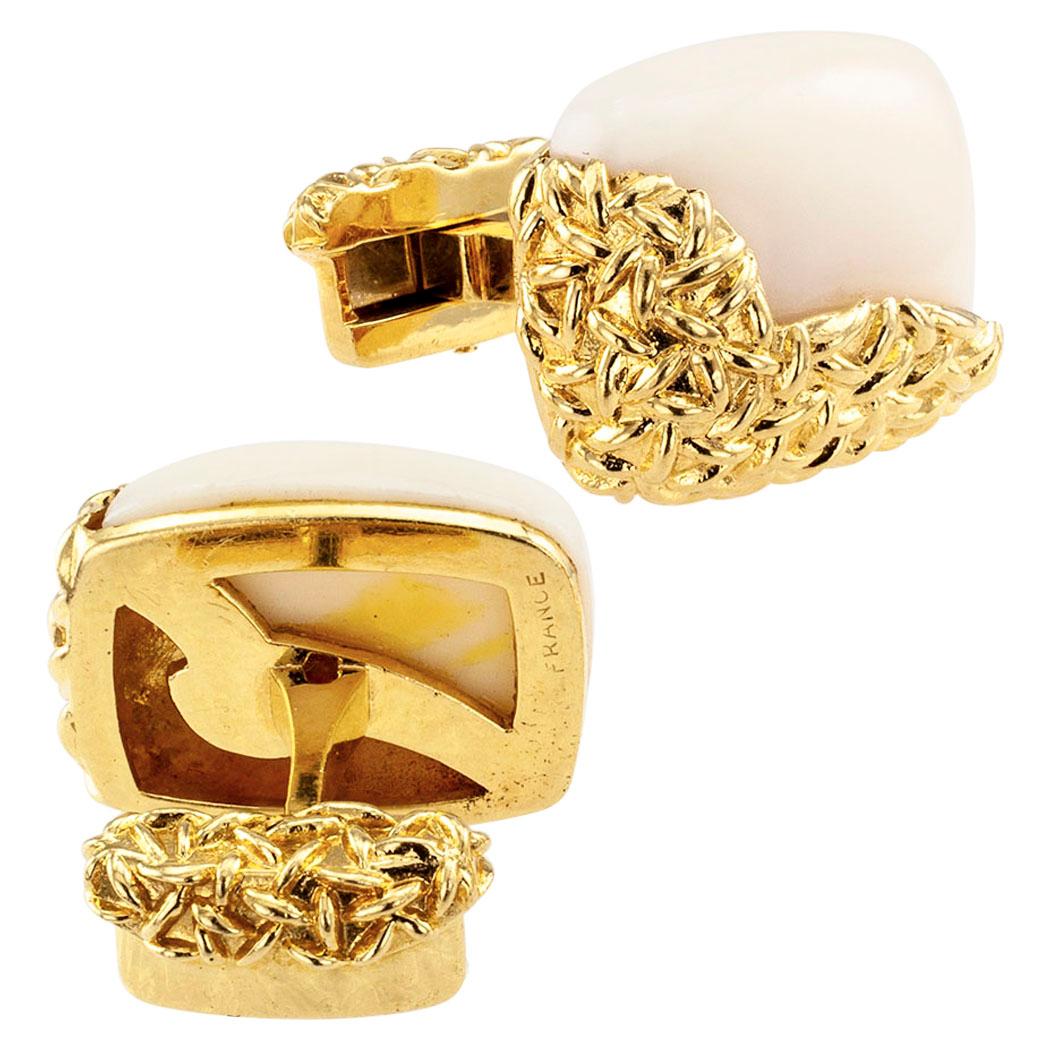 French white coral and gold cufflinks circa 1970. The cushion-shaped faces are set with conforming cabochon white coral capped by bright gold motifs sporting a rice grain texture, mounted in 18-karat gold with French hallmarks. This simple