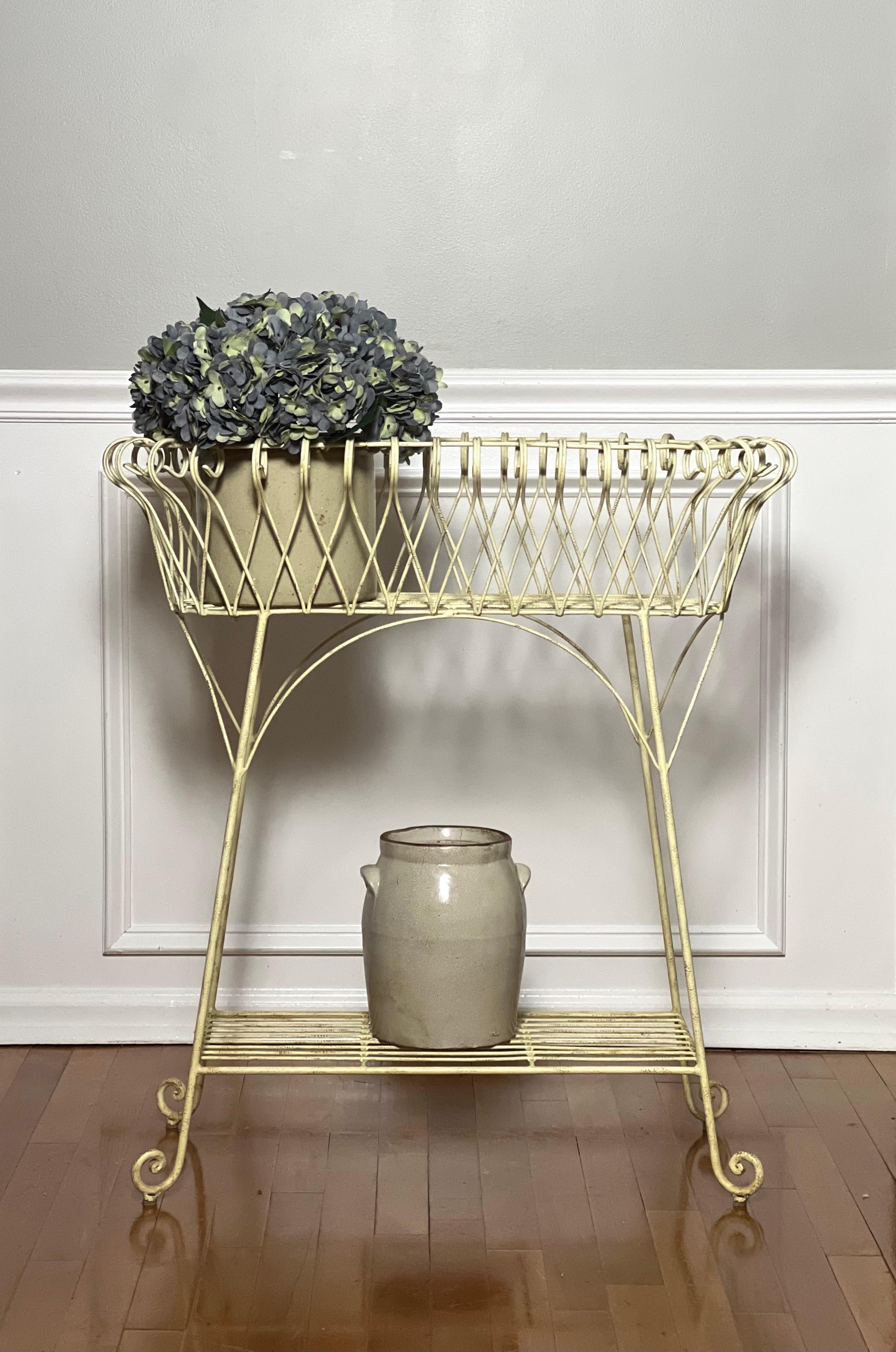 French white painted iron jardiniere or plant stand, circa early 20th century. Oblong in shape with a sculpted form having a light and airy design incorporating geometrical and curvilinear elements. Well crafted and sturdy, the stand has an amply