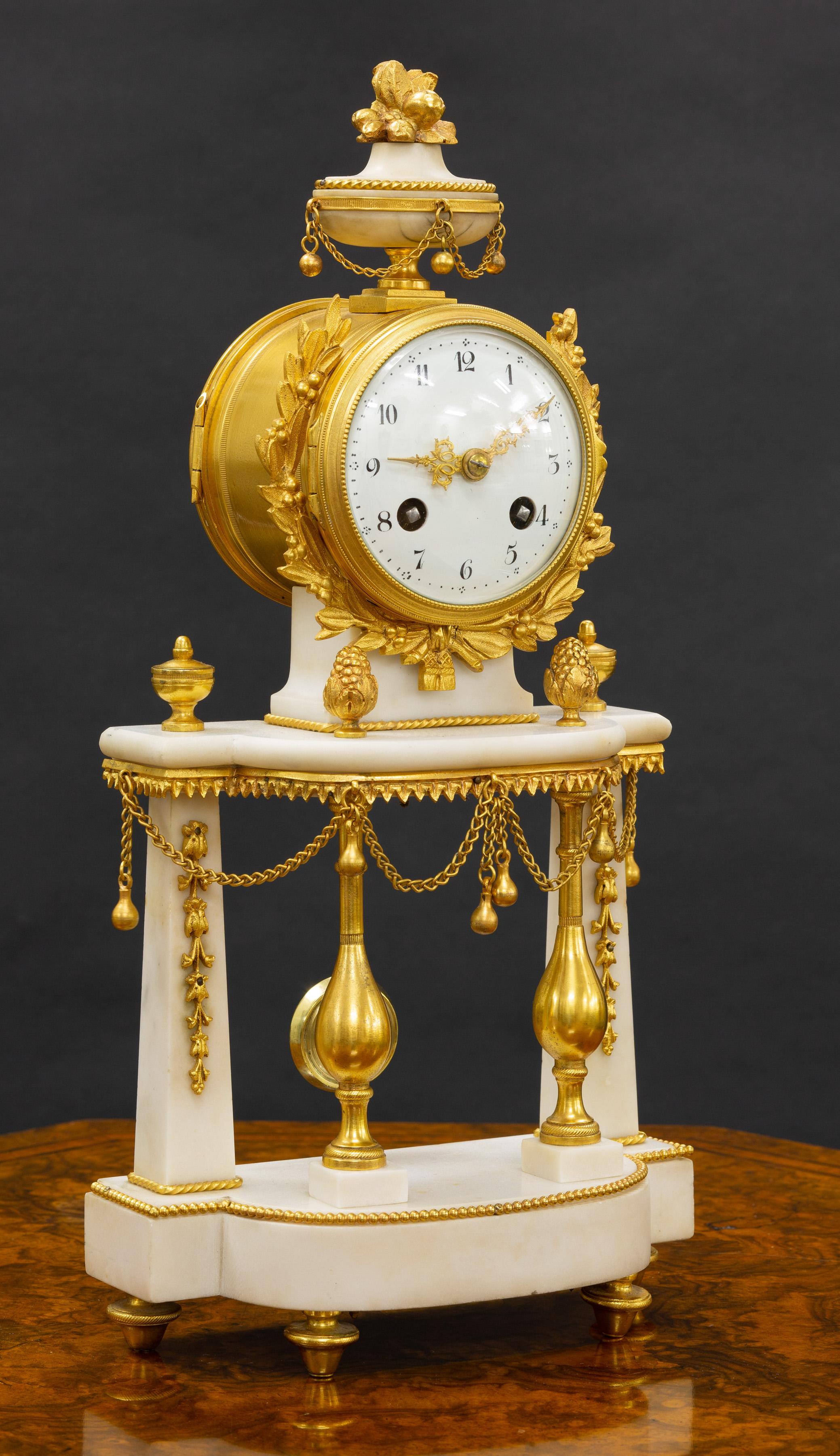 French ormolu and white marble pillar clock with ormolu mounts surmounted by an ornate finial with and standing on four gilded bun feet. 

The four pillars have fine ormolu mounts and are decorated with ornate chain swags. 

Enamel dial with