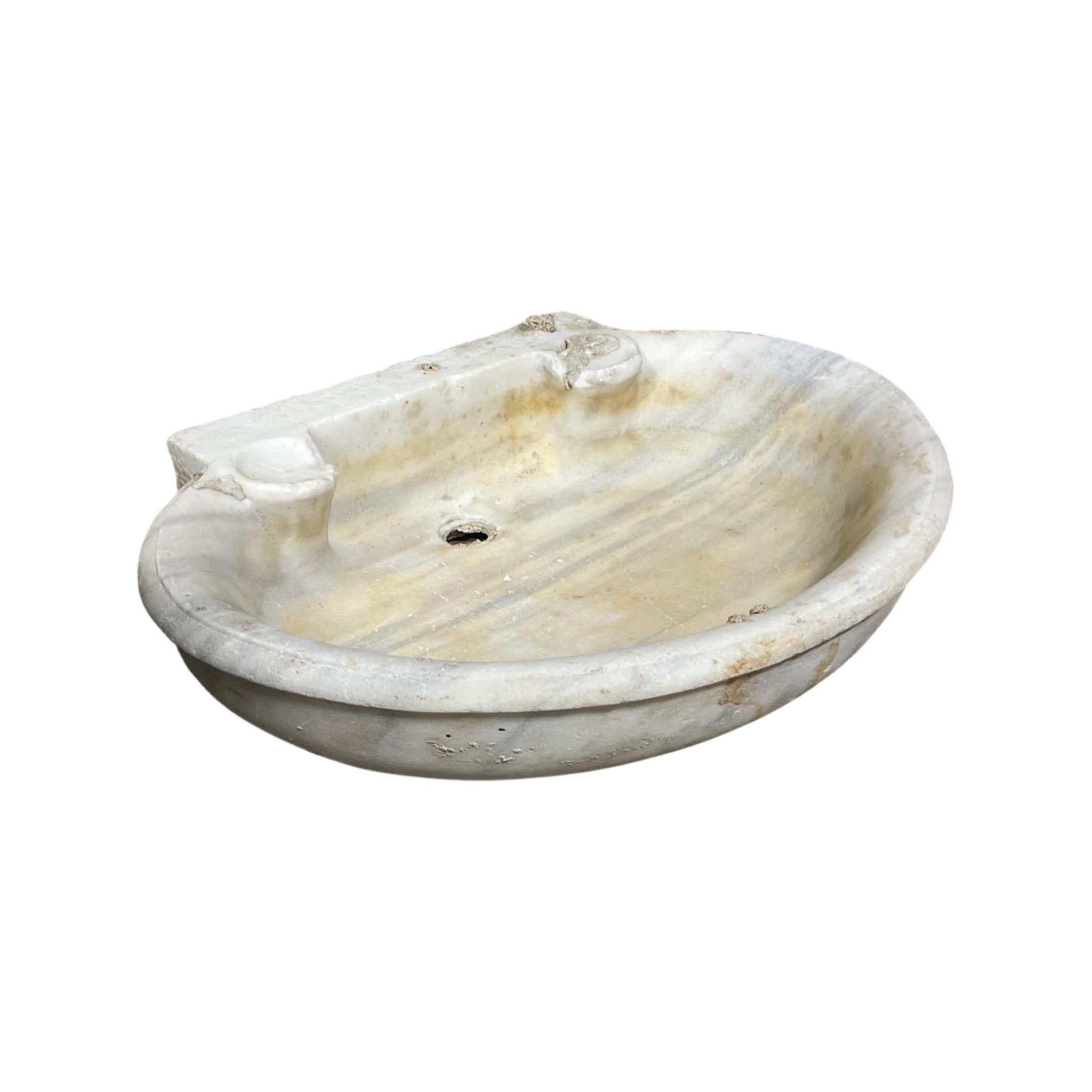 This 18th century French white marble oval sink is an elegant basin crafted from natural marble. Featuring an oval design and a smooth polished surface, it provides exceptional durability, has a timeless design, and is easy to clean and maintain.