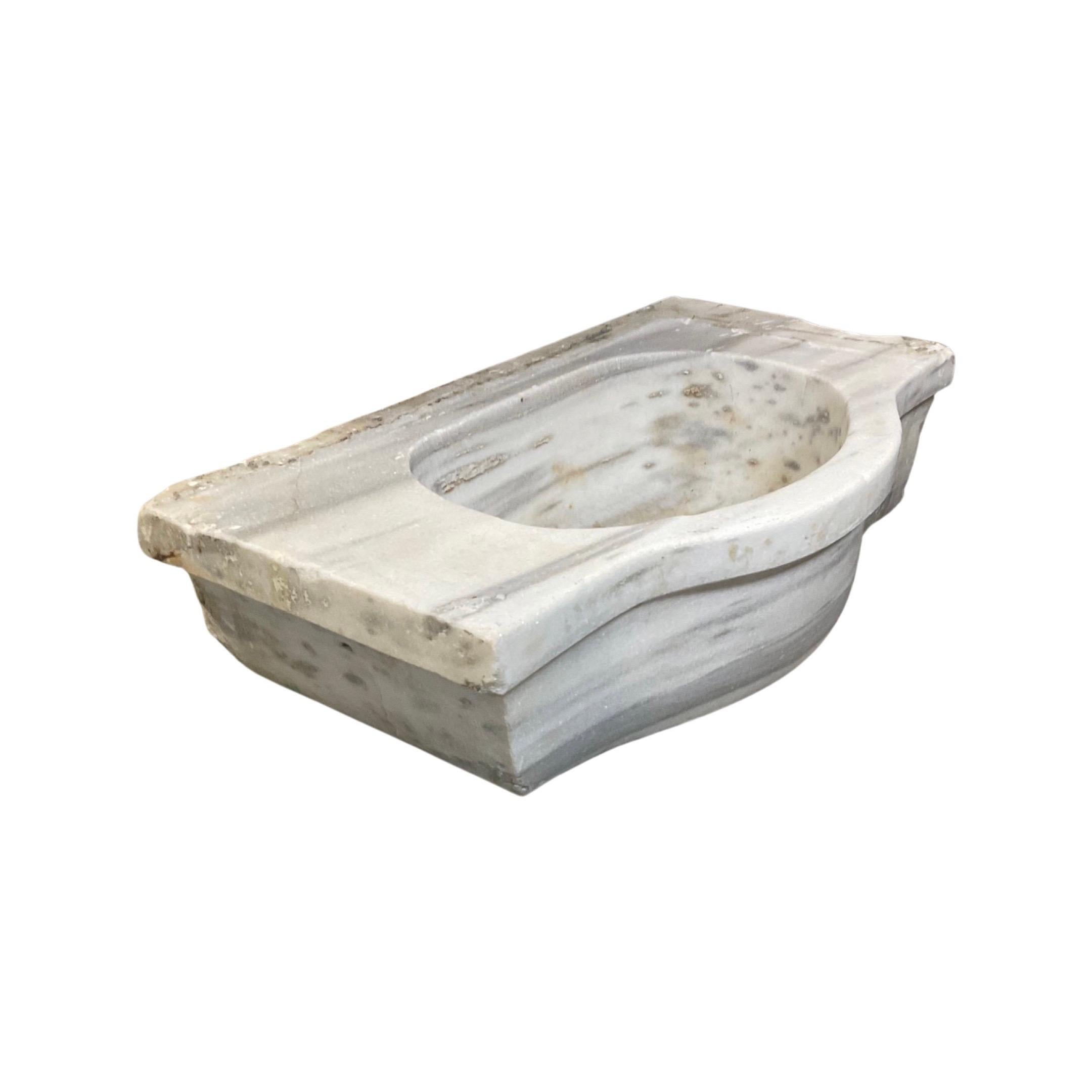 Experience luxurious old-world style with this beautiful 18th century French White Marble Sink. Expertly crafted from the highest-quality marble, this sink offers premium durability and timeless elegance. Add a touch of sophistication to your
